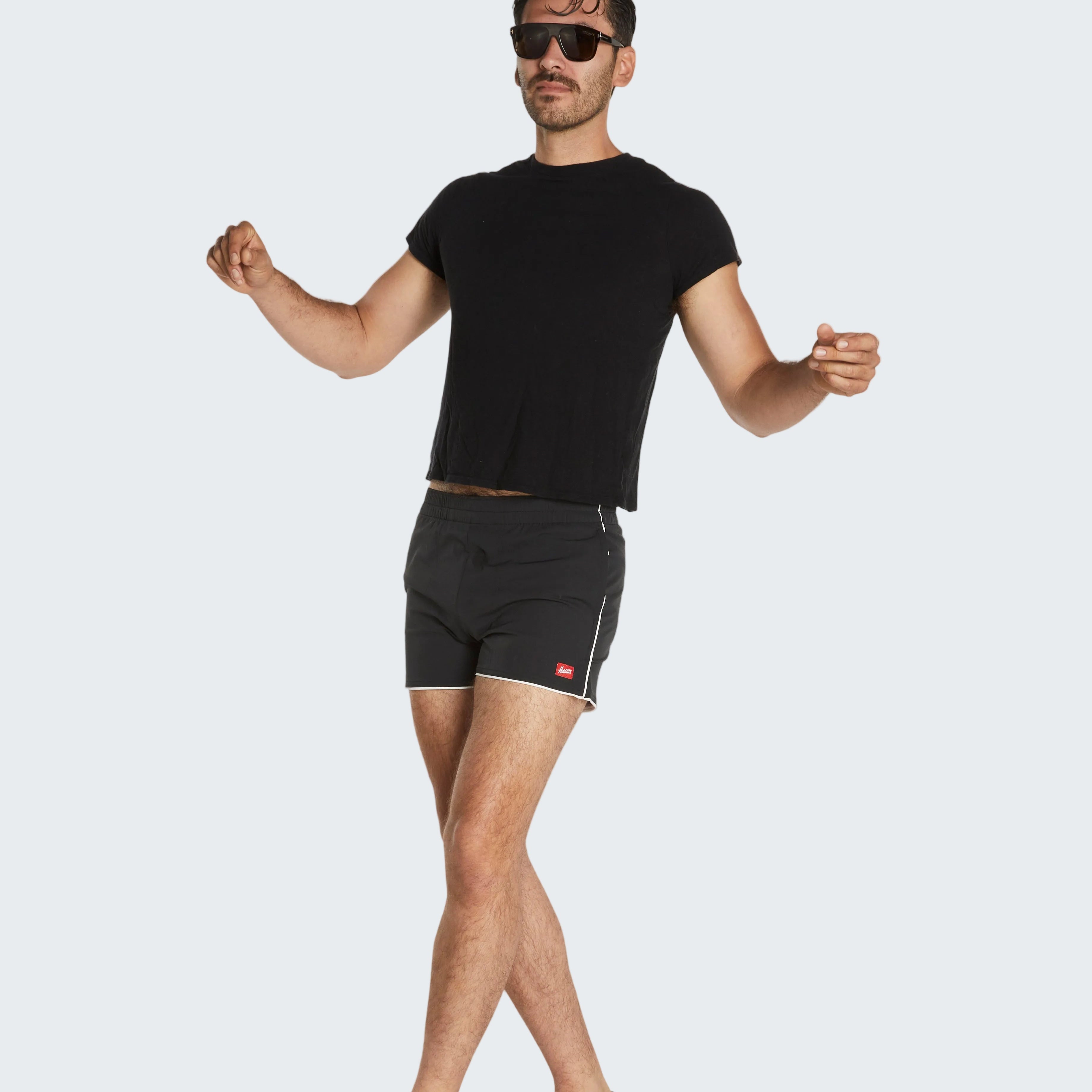 Man wearing a black t-shirt and black boxer briefs on a white background