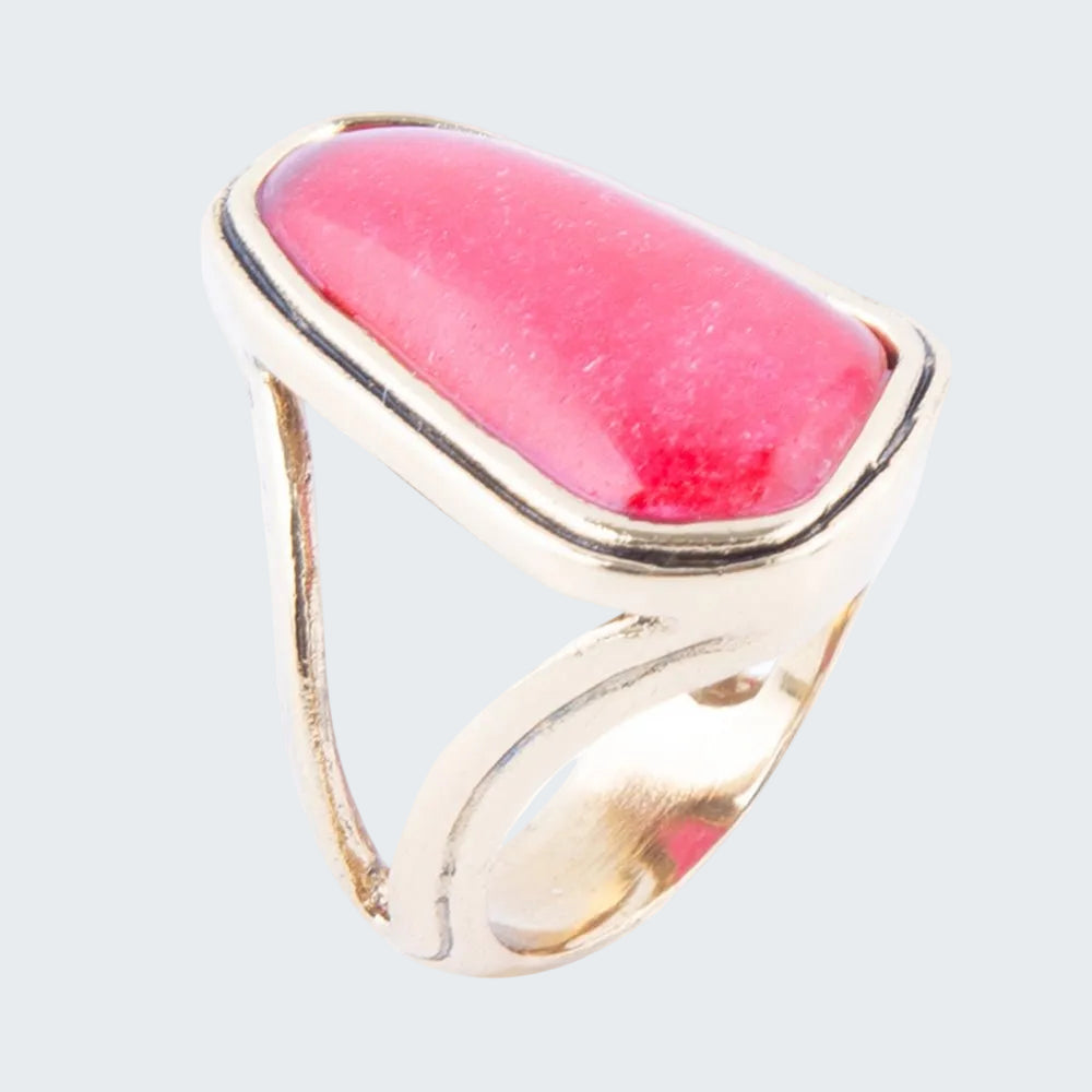 Ring with pink stone and gold band on a white background