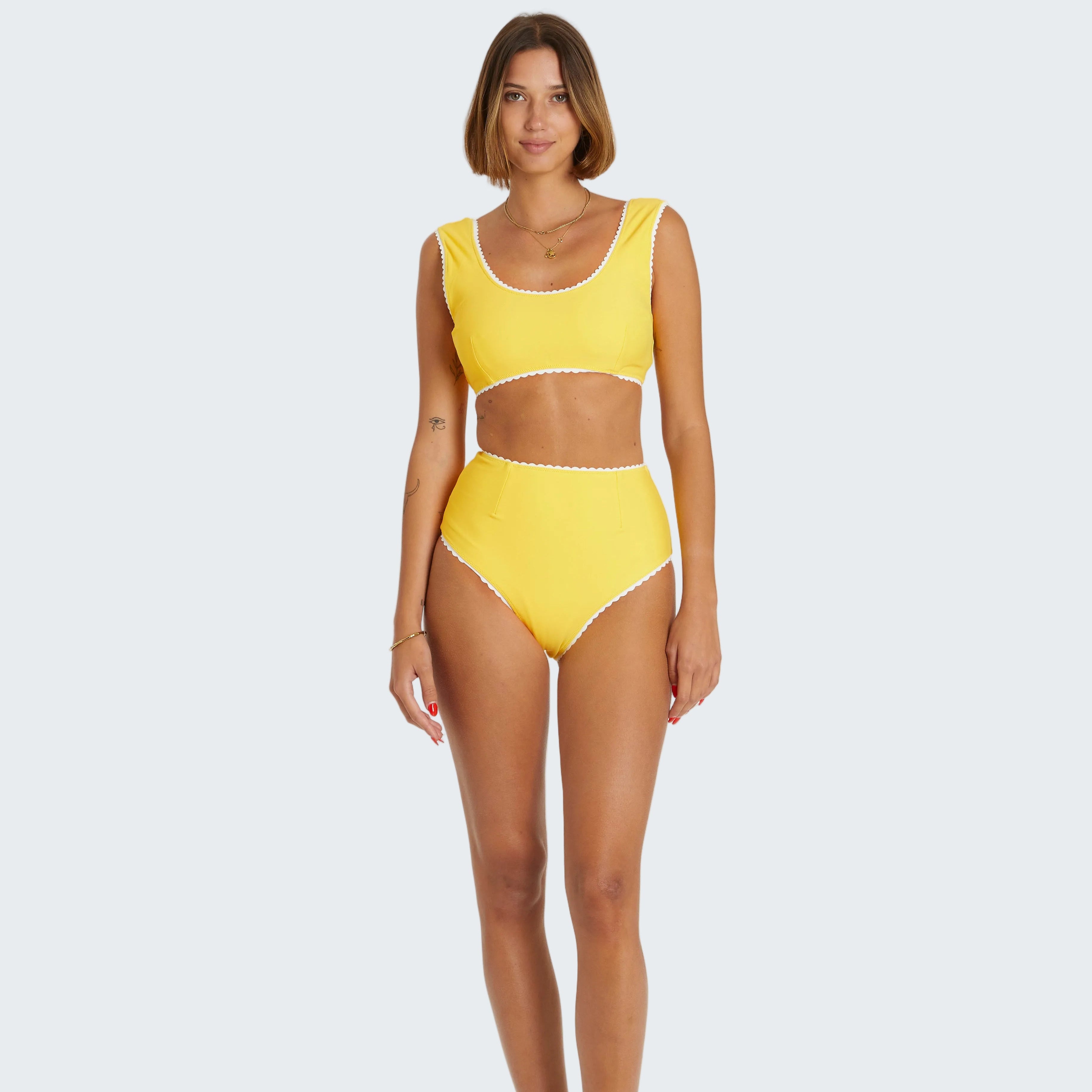 Woman wearing a yellow bikini set on a white background