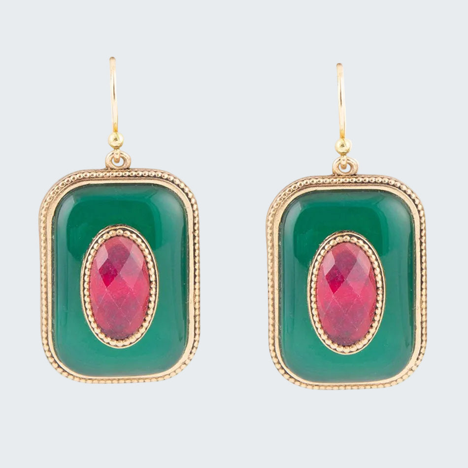 Green earrings with pink gemstones on a white background