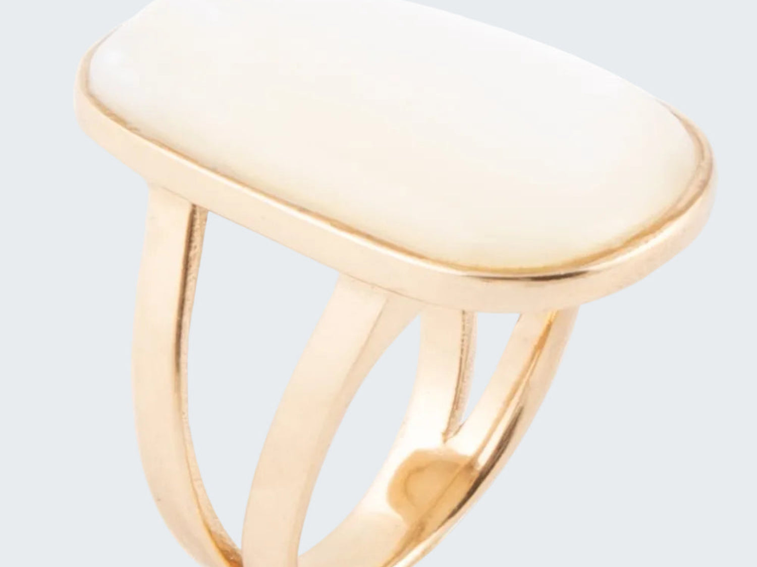 Gold ring with a white stone on a white background