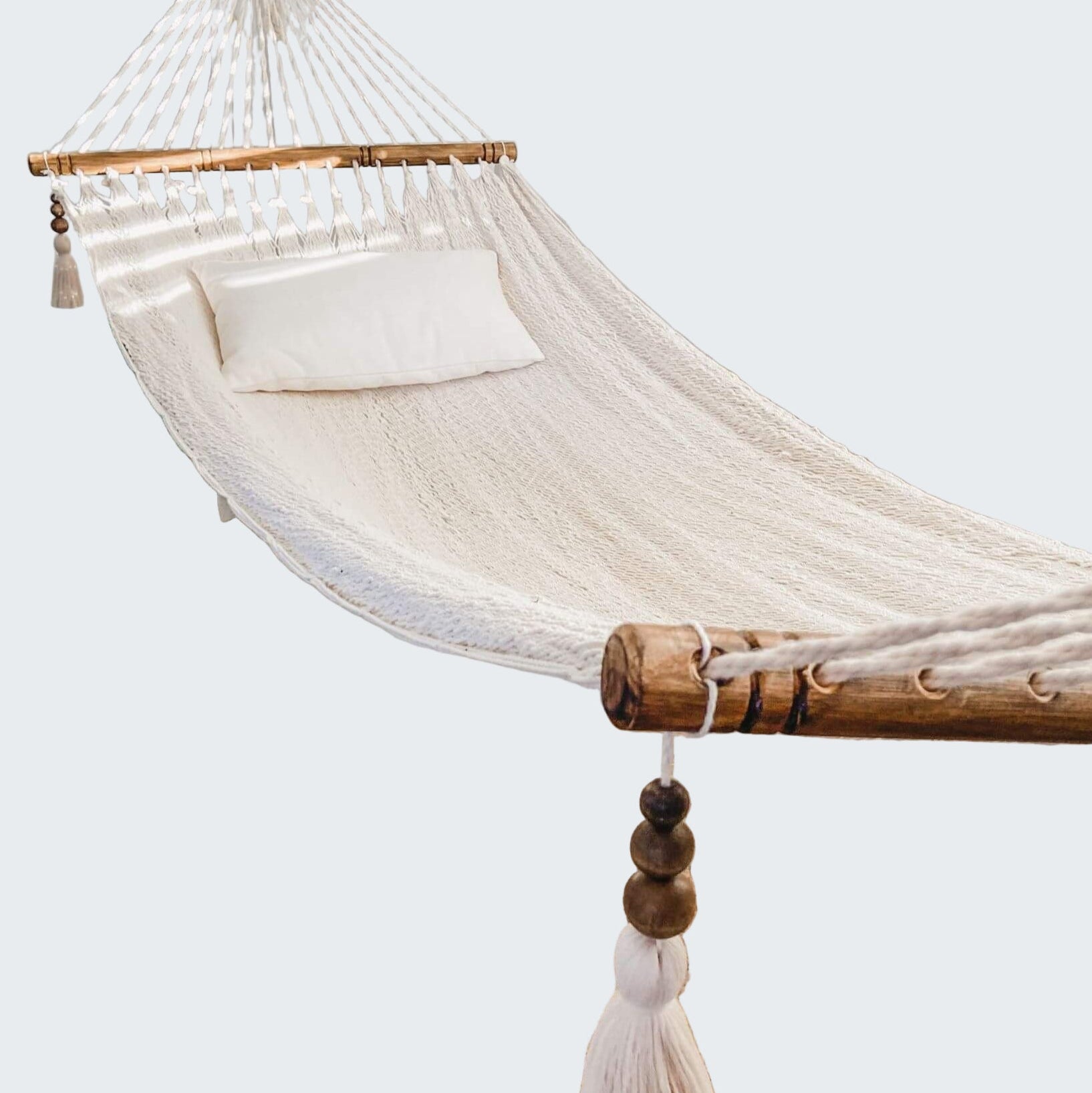 White hammock in a room with a textured rug and decorative elements.