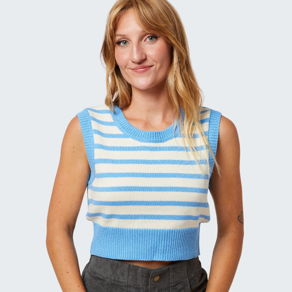 Woman wearing a blue and white striped sleeveless top with gray shorts on a white background