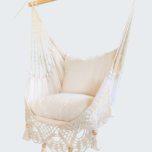 White hammock chair with wooden frame in a room with decorative elements.