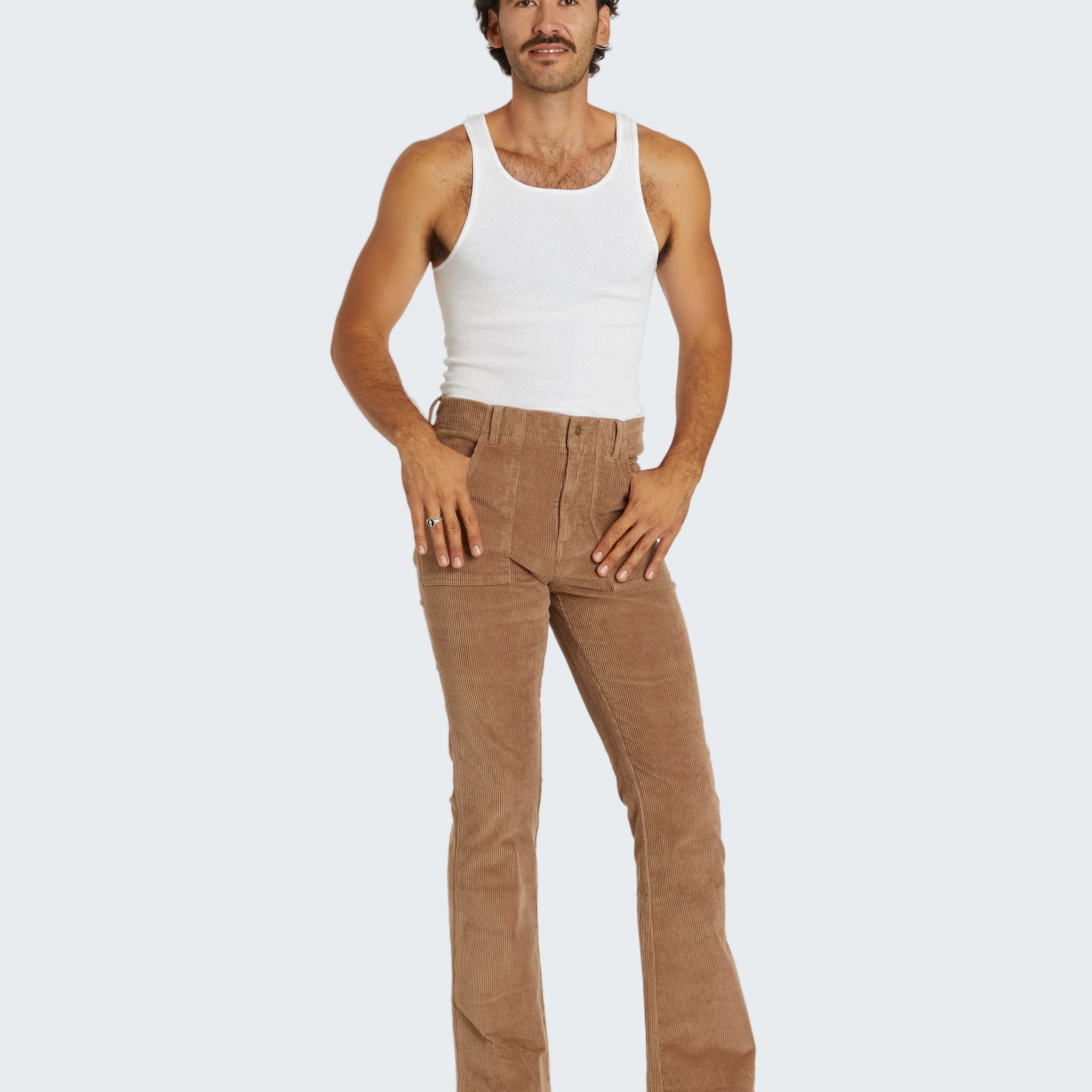 Man wearing a white tank top and brown pants on a white background