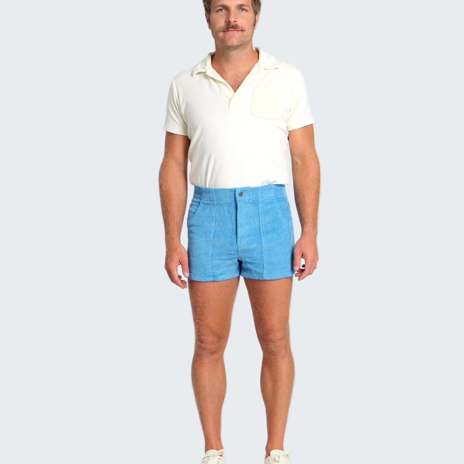 Man wearing a white polo shirt and blue shorts on a white background