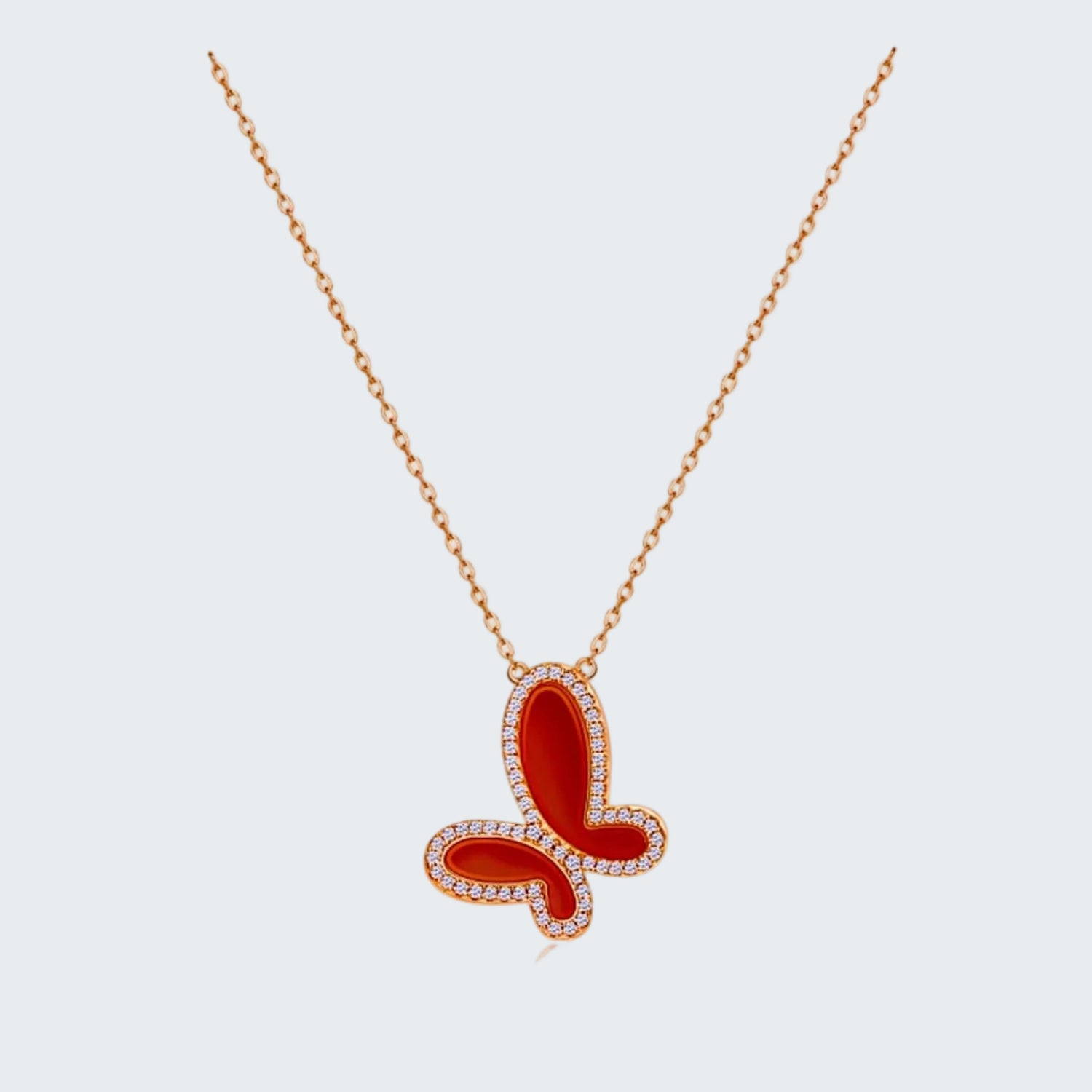 Red butterfly pendant necklace on a white background