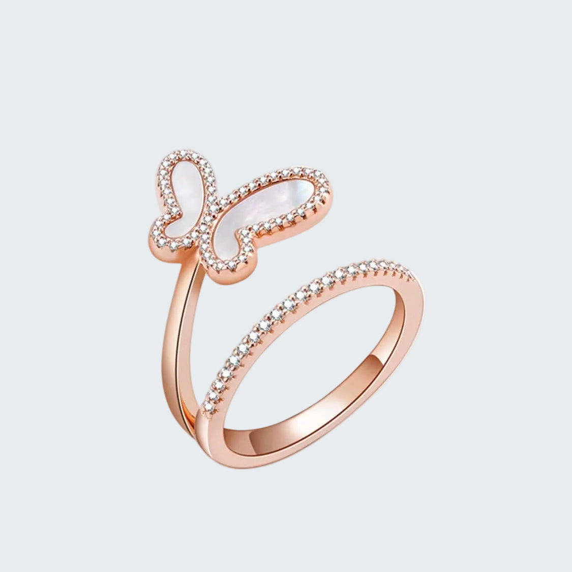 Rose gold butterfly ring with white gemstone on a white background