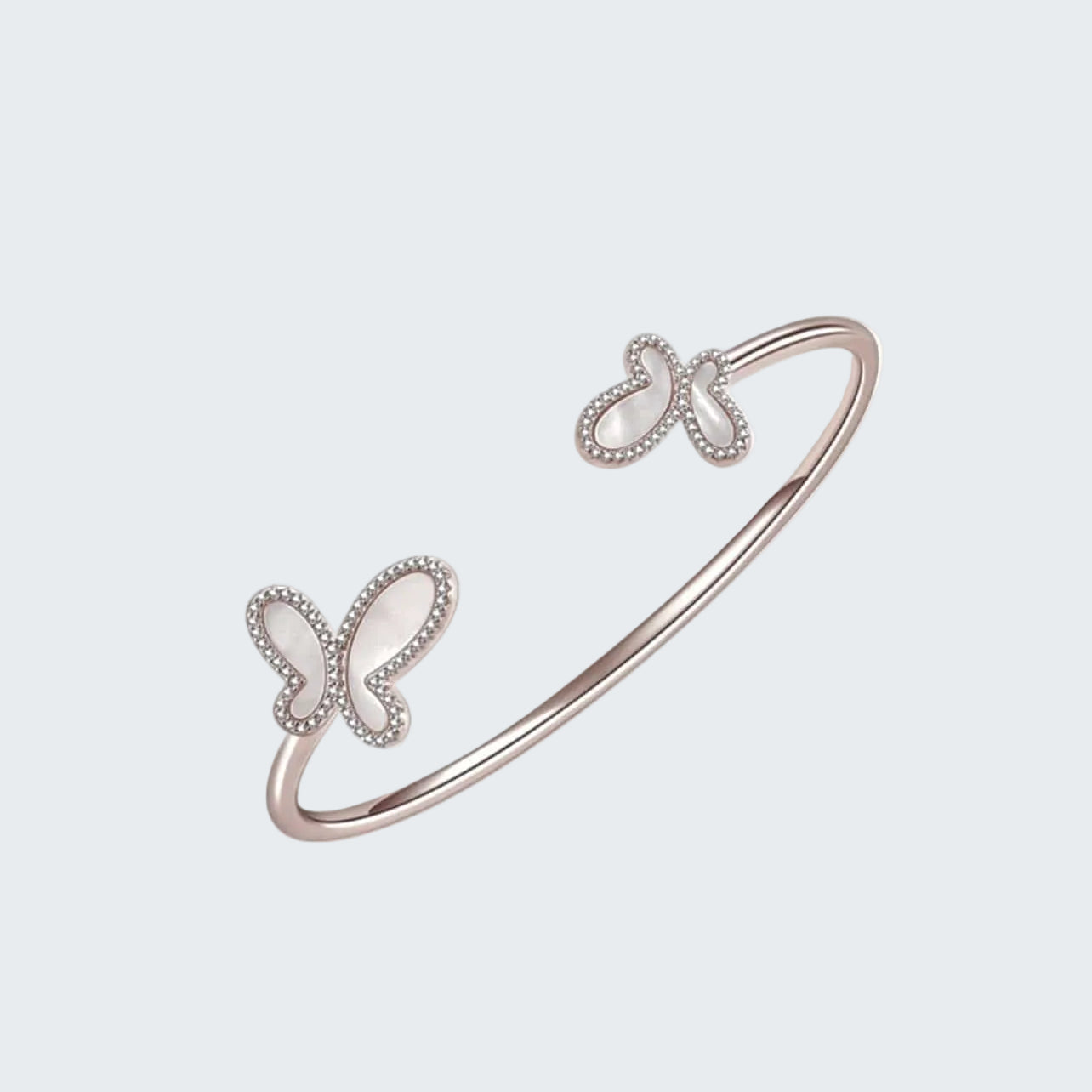 Rose gold bracelet with butterfly designs on a white background