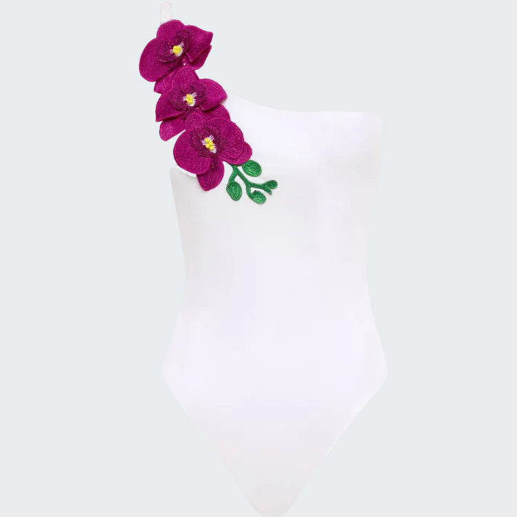 White swimsuit with purple floral design on a white background