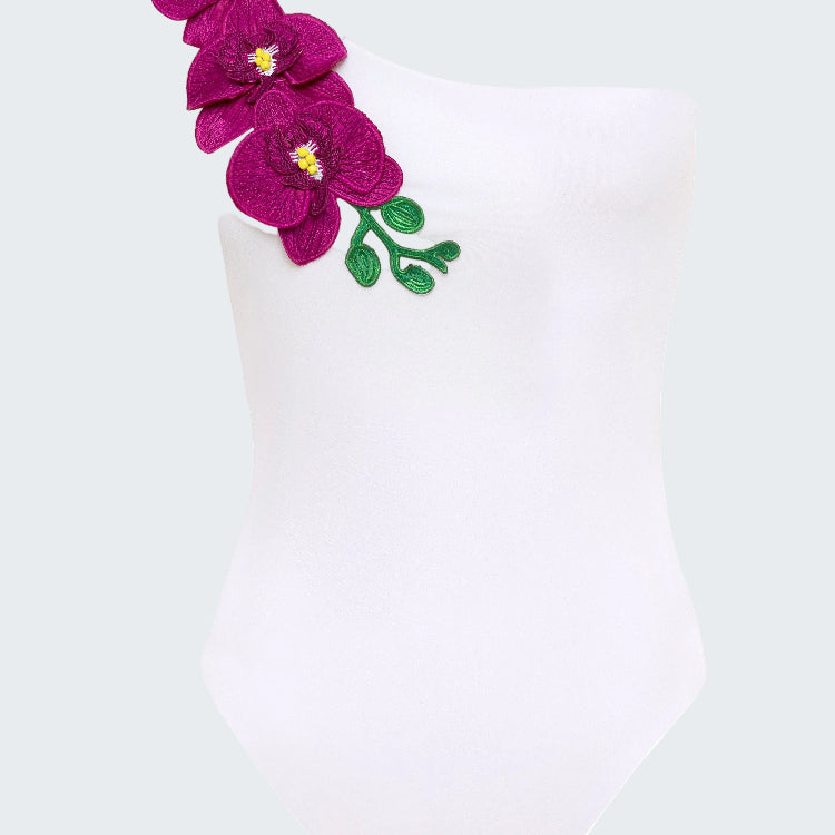 White swimsuit with purple floral design on a white background