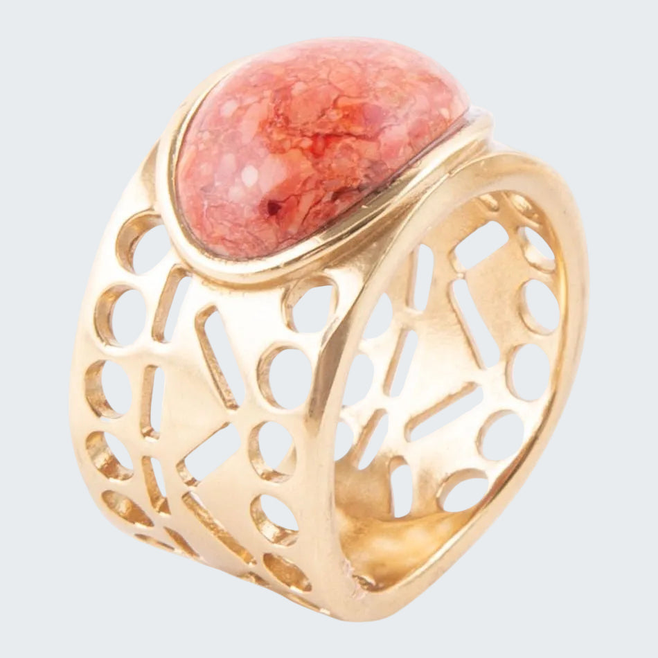 Gold ring with a red stone on a white background