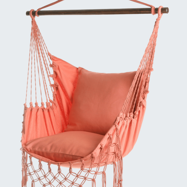 Coral hammock chair with tassels on a white background