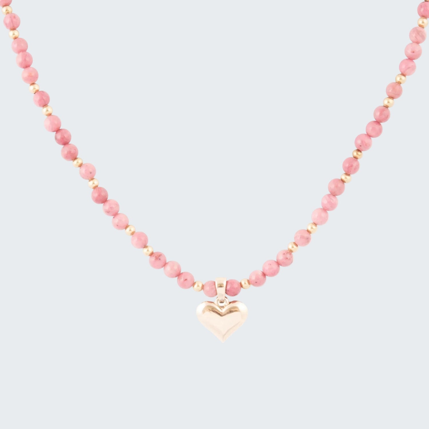 Necklace with pink beads and a heart-shaped pendant on a white background