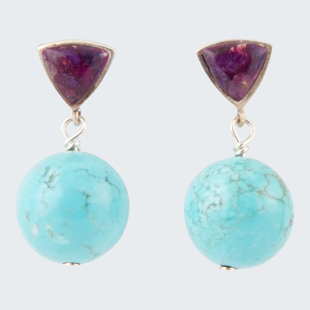Pair of earrings with purple triangular stones and turquoise round stones on a white background