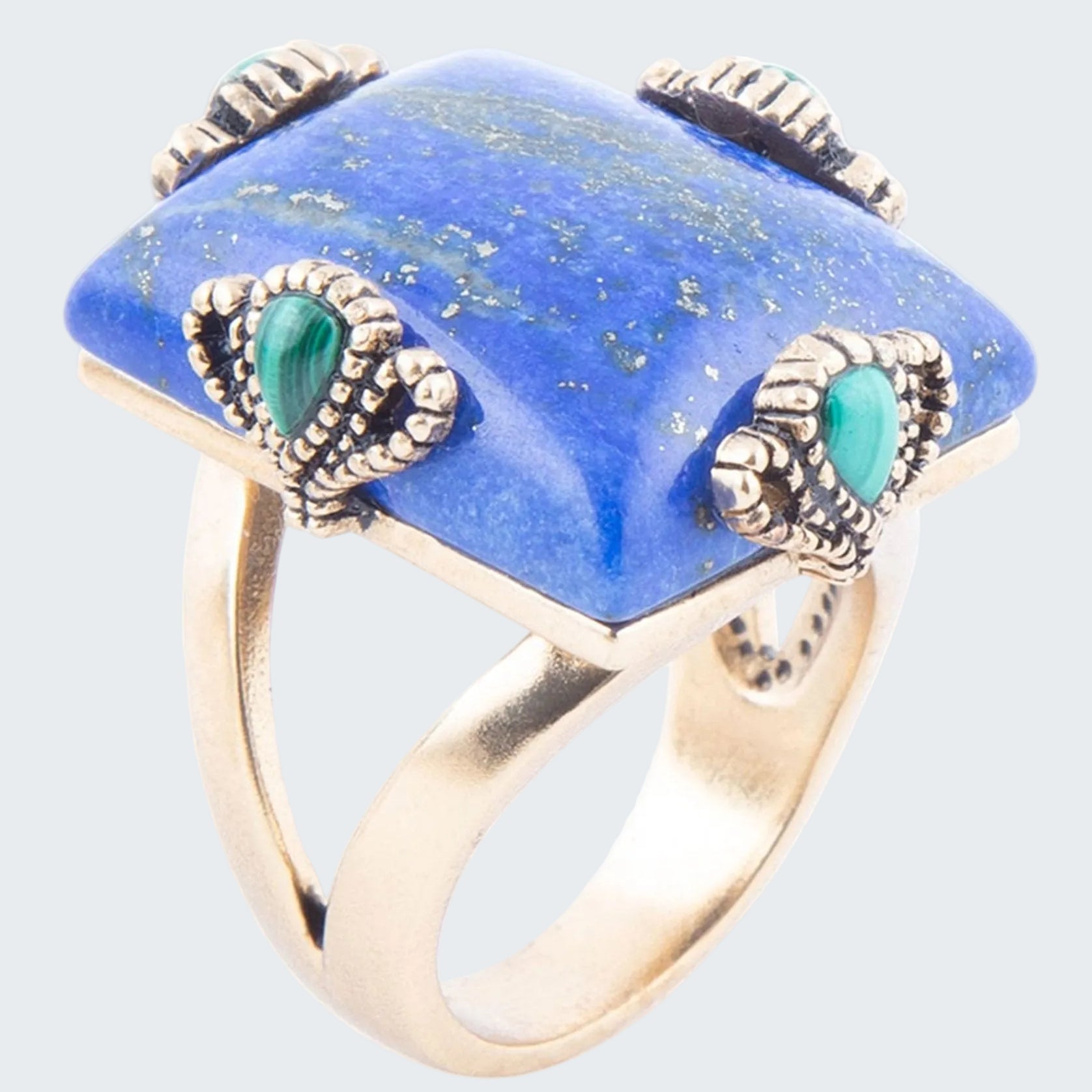 Ring with blue stone and green accents on a white background