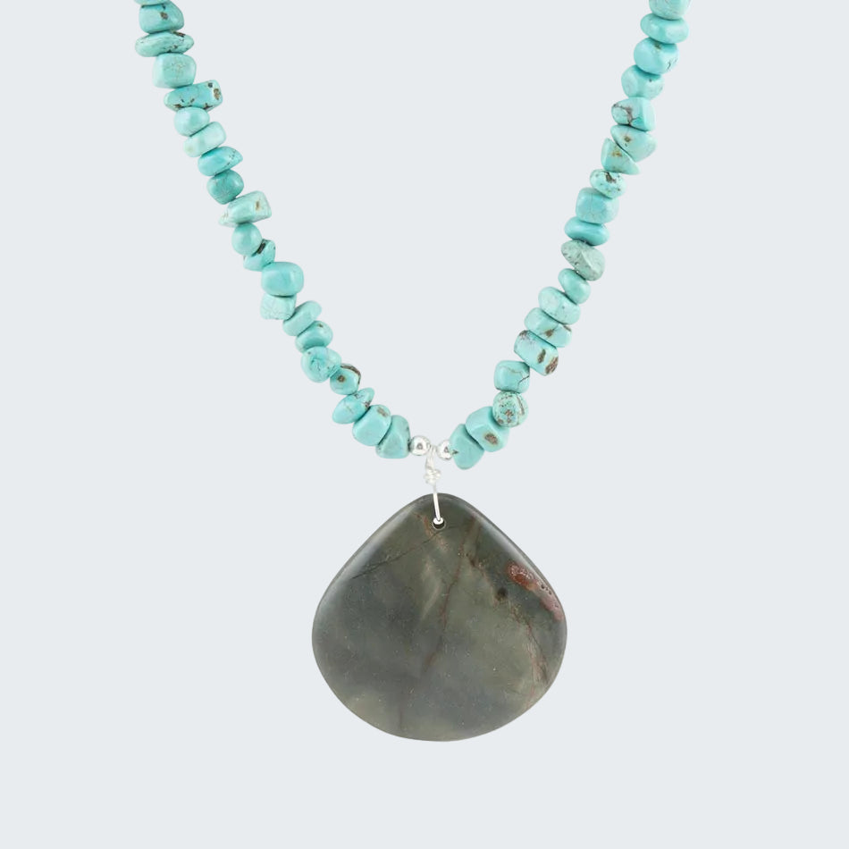 Turquoise beaded necklace with a large stone pendant on a white background