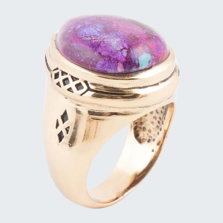Gold ring with a colorful stone on a white background