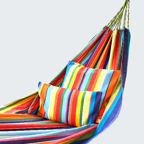 Colorful striped hammock on a wooden deck with a scenic background