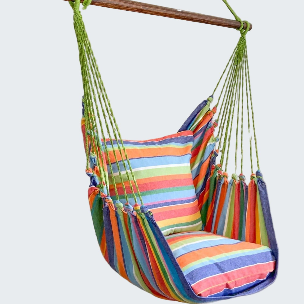 Colorful striped hammock chair hanging in a room with decorative elements.