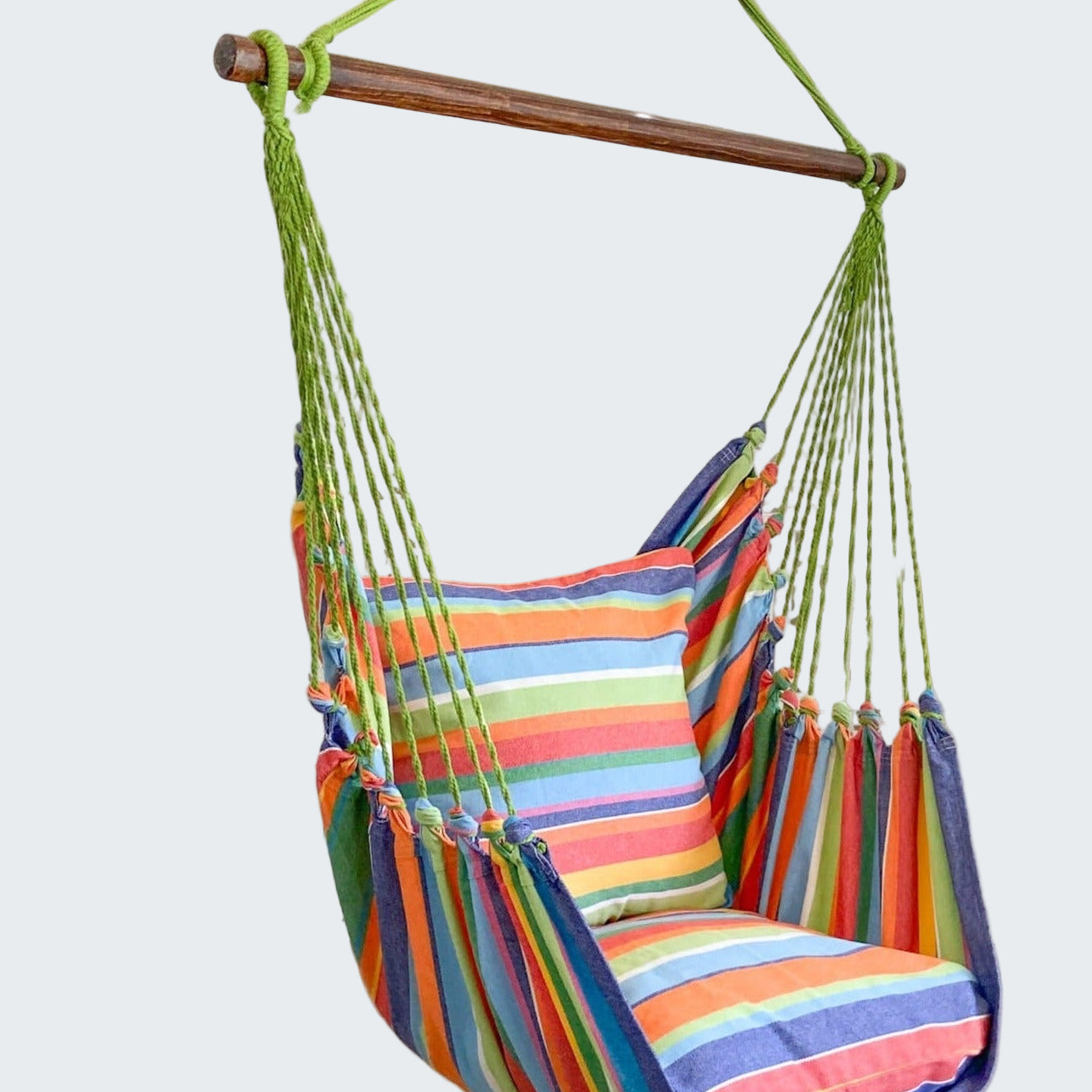 Colorful striped hammock chair hanging in a room with decorative elements.