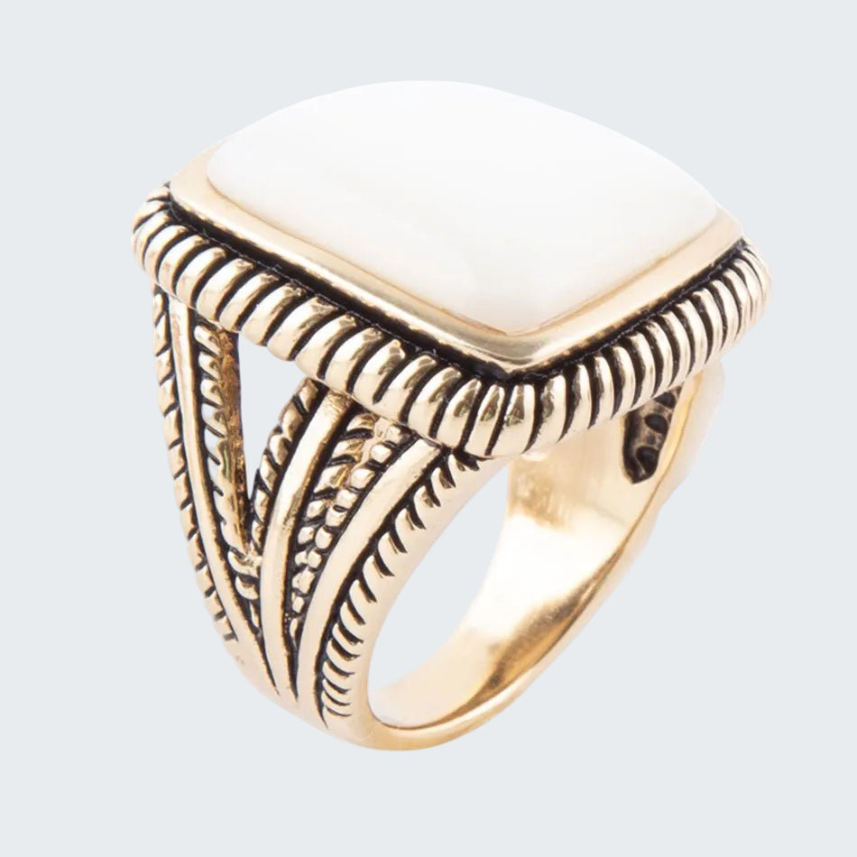 Gold ring with intricate design on a white background