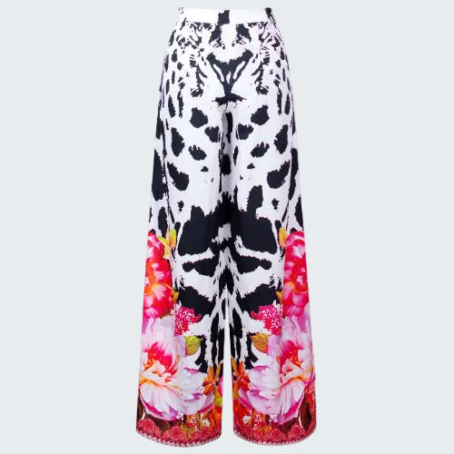 Wide-leg pants with black and white abstract pattern and colorful floral design on a white background