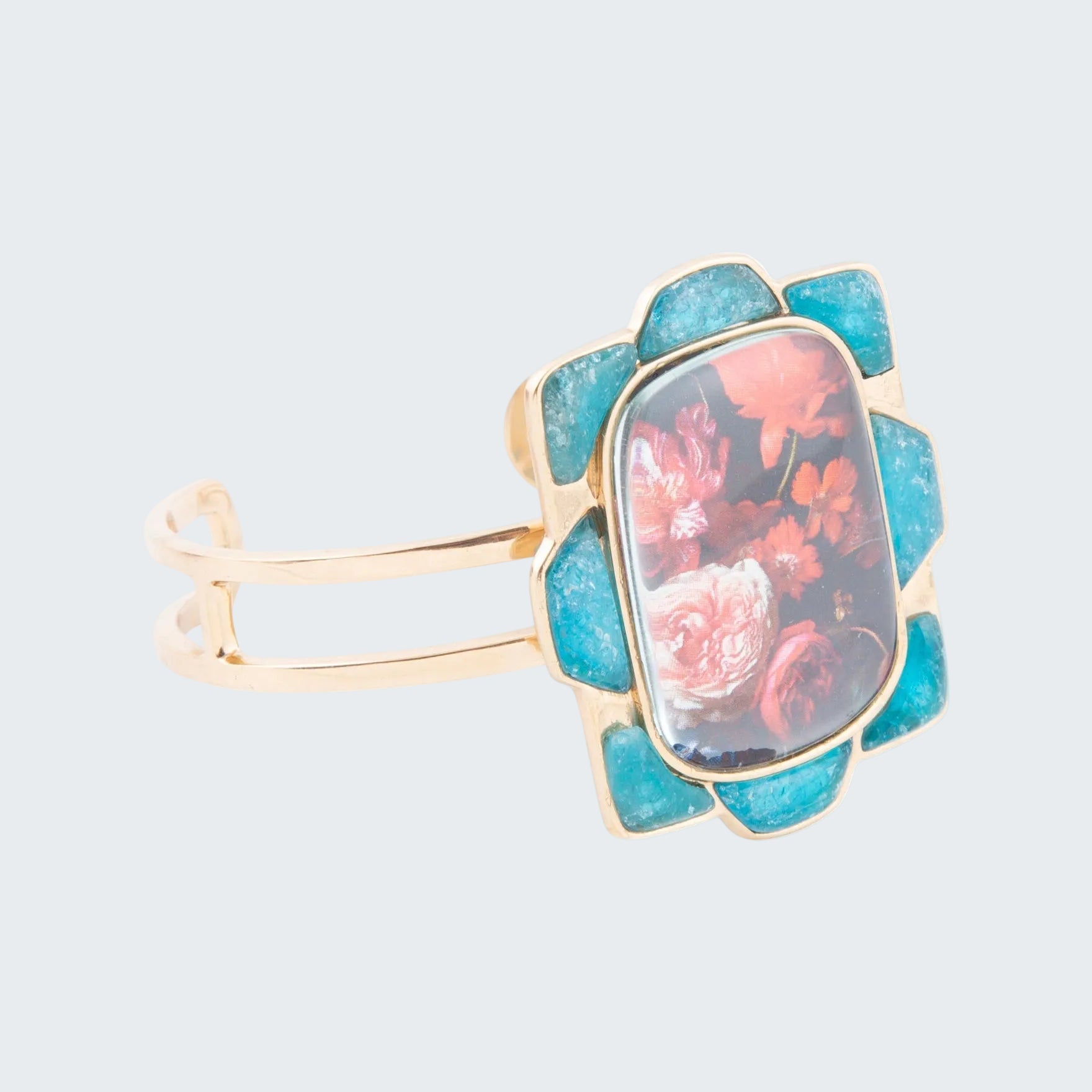 Ring with floral design and turquoise stone on a white background