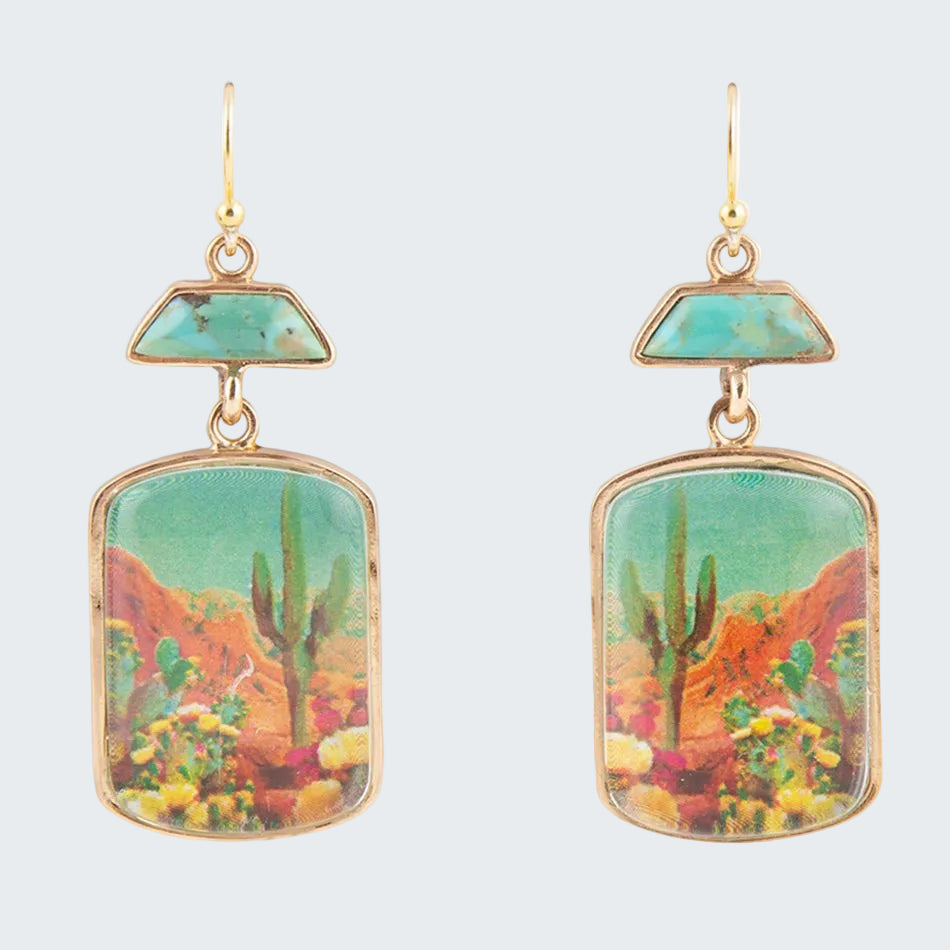 Pair of earrings with desert landscape design on a white background