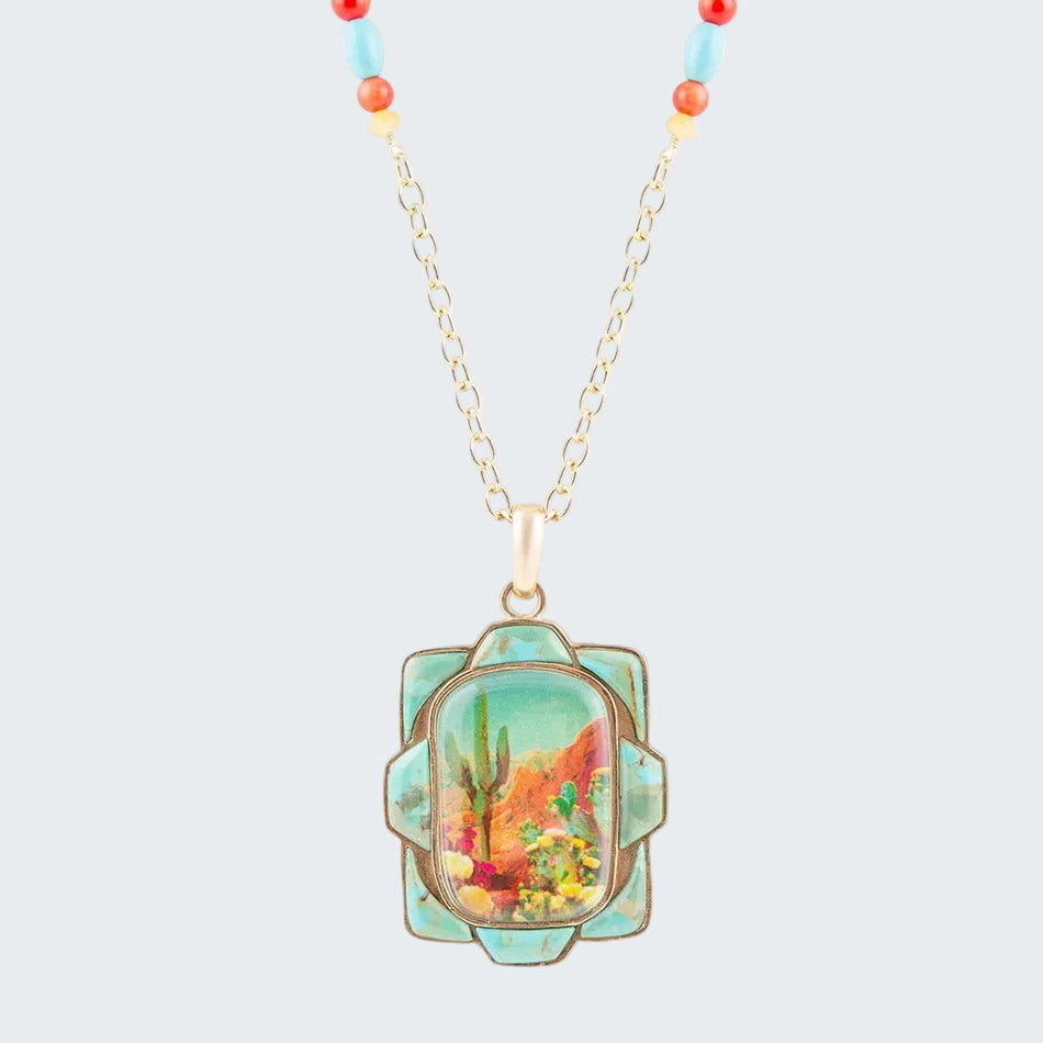 Necklace with a colorful pendant featuring a desert scene on a white background