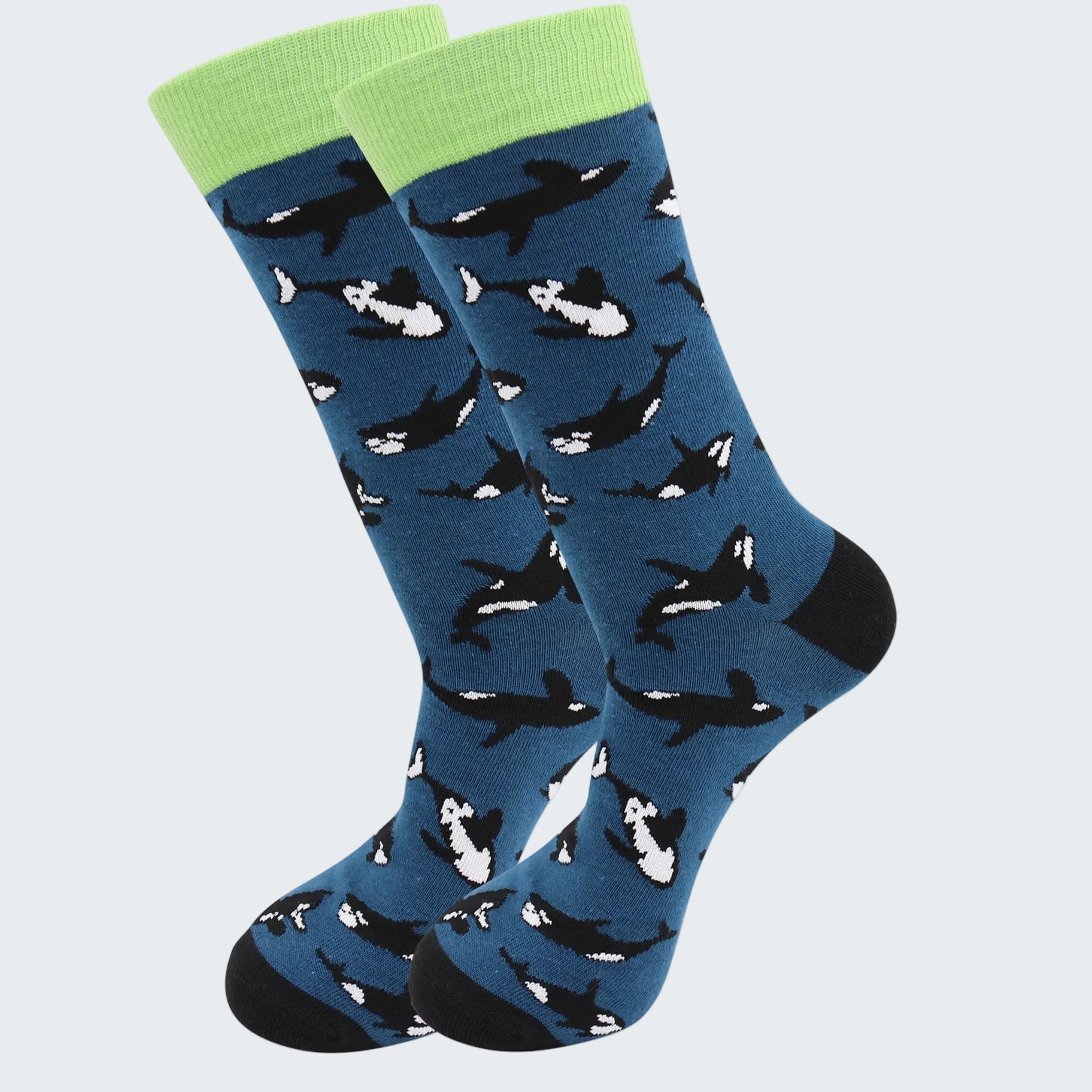 Blue socks with whale pattern and green cuffs on a white background