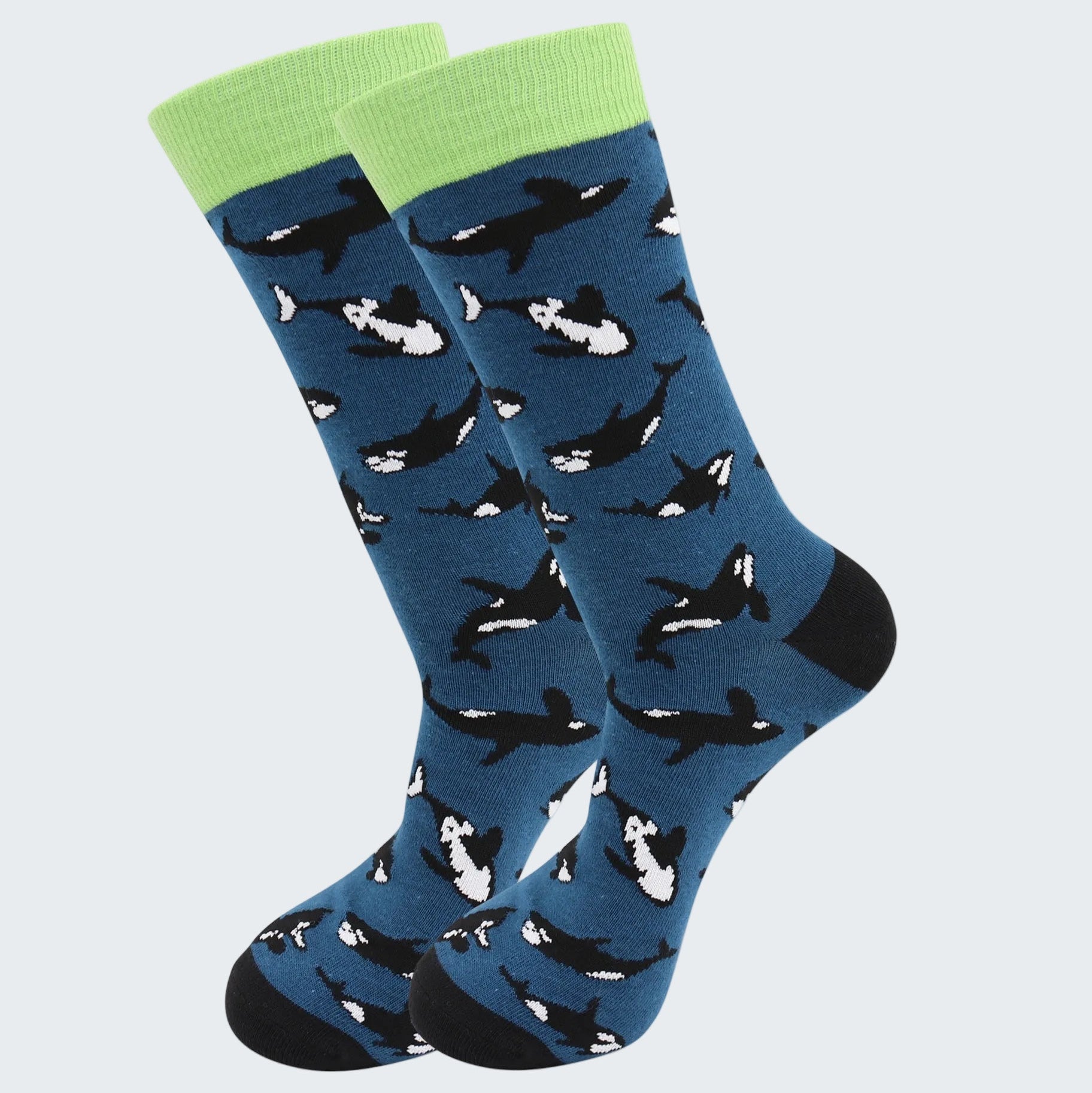 Blue socks with whale pattern and green cuffs on a white background