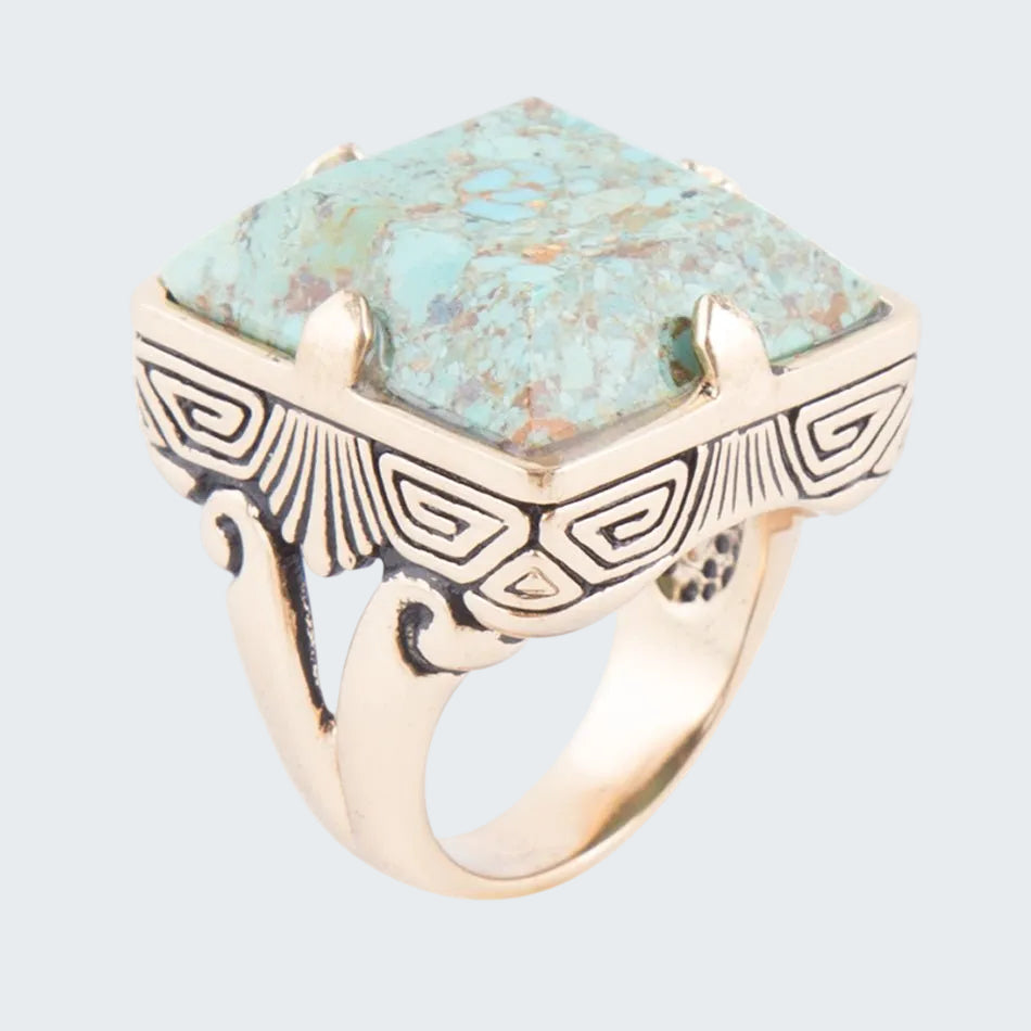 Ring with turquoise stone and gold-tone band on a white background