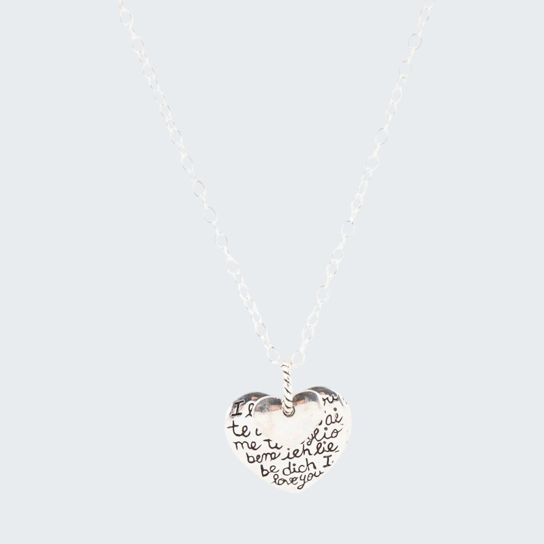 Heart-shaped pendant necklace with engraved text on a white background