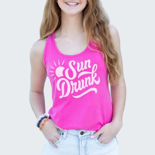 Woman wearing a pink 'Sun Drunk' tank top by a pool