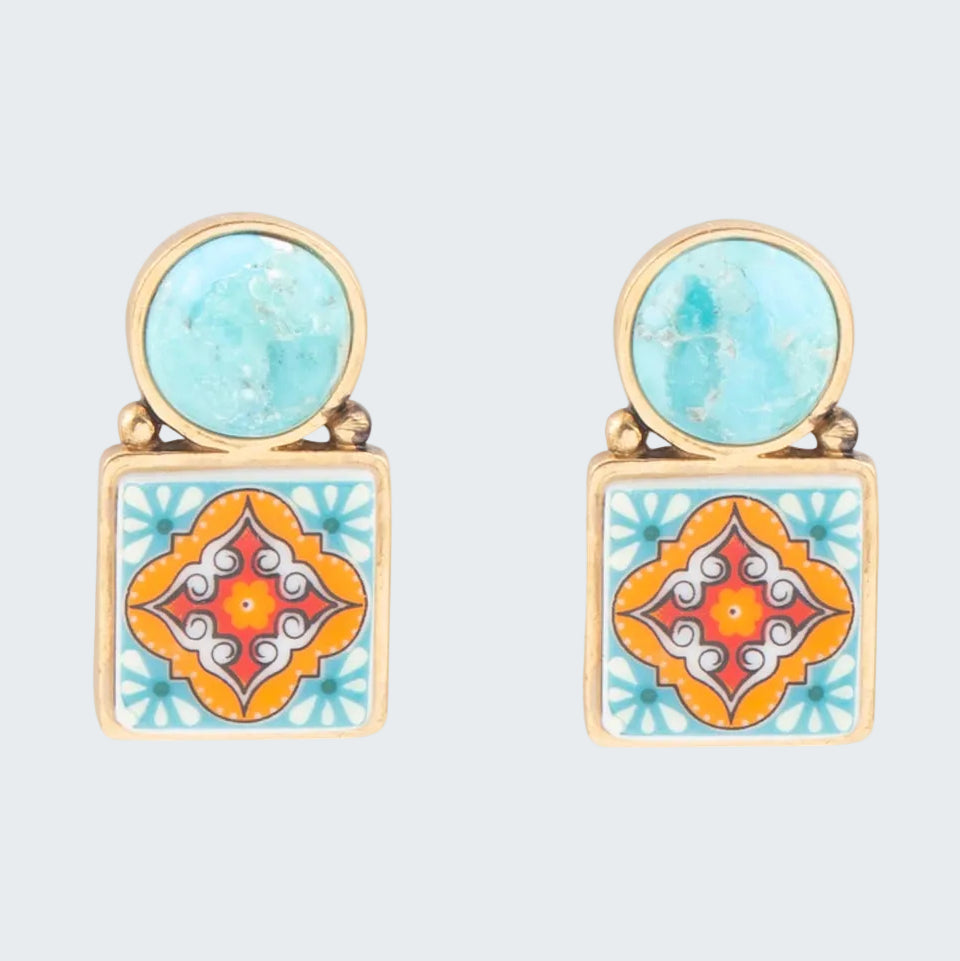 Pair of earrings with turquoise and orange geometric designs on a white background