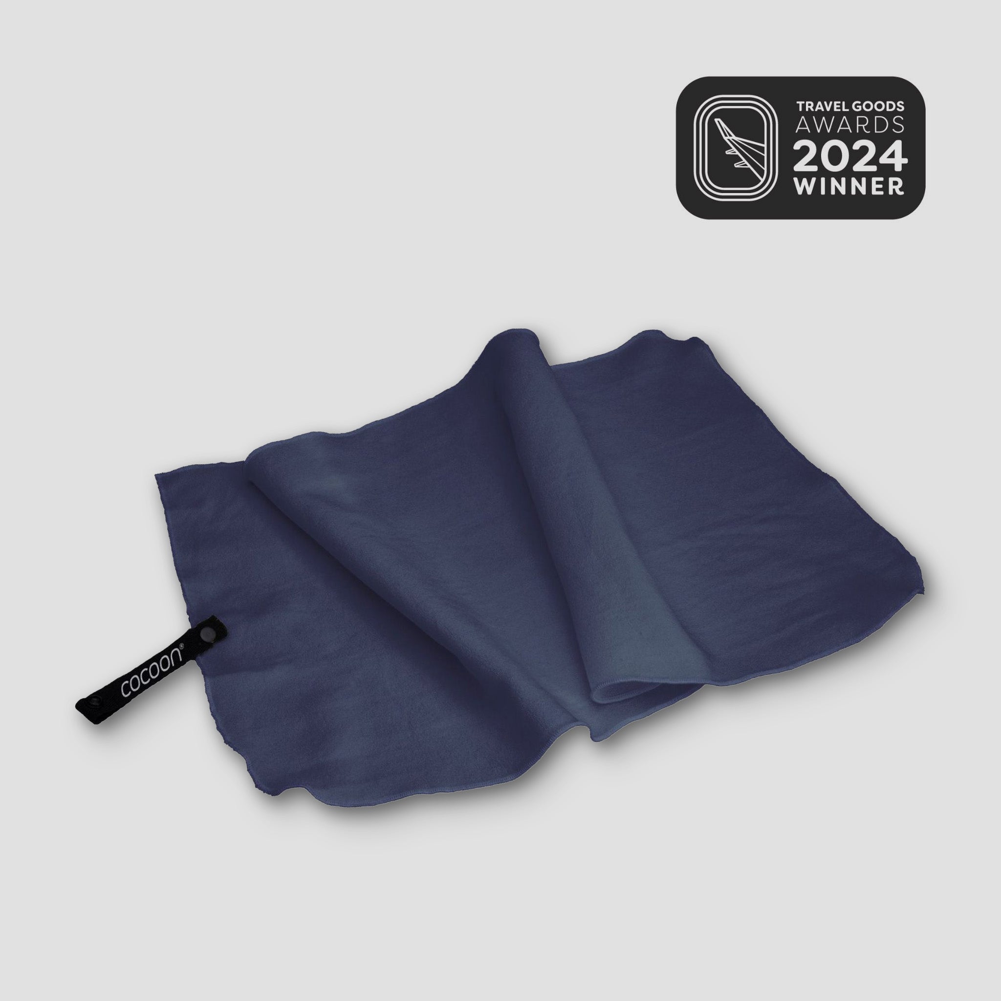 Blue towel with a brand logo on a light gray background, featuring the 2024 Travel Goods Awards winner badge.