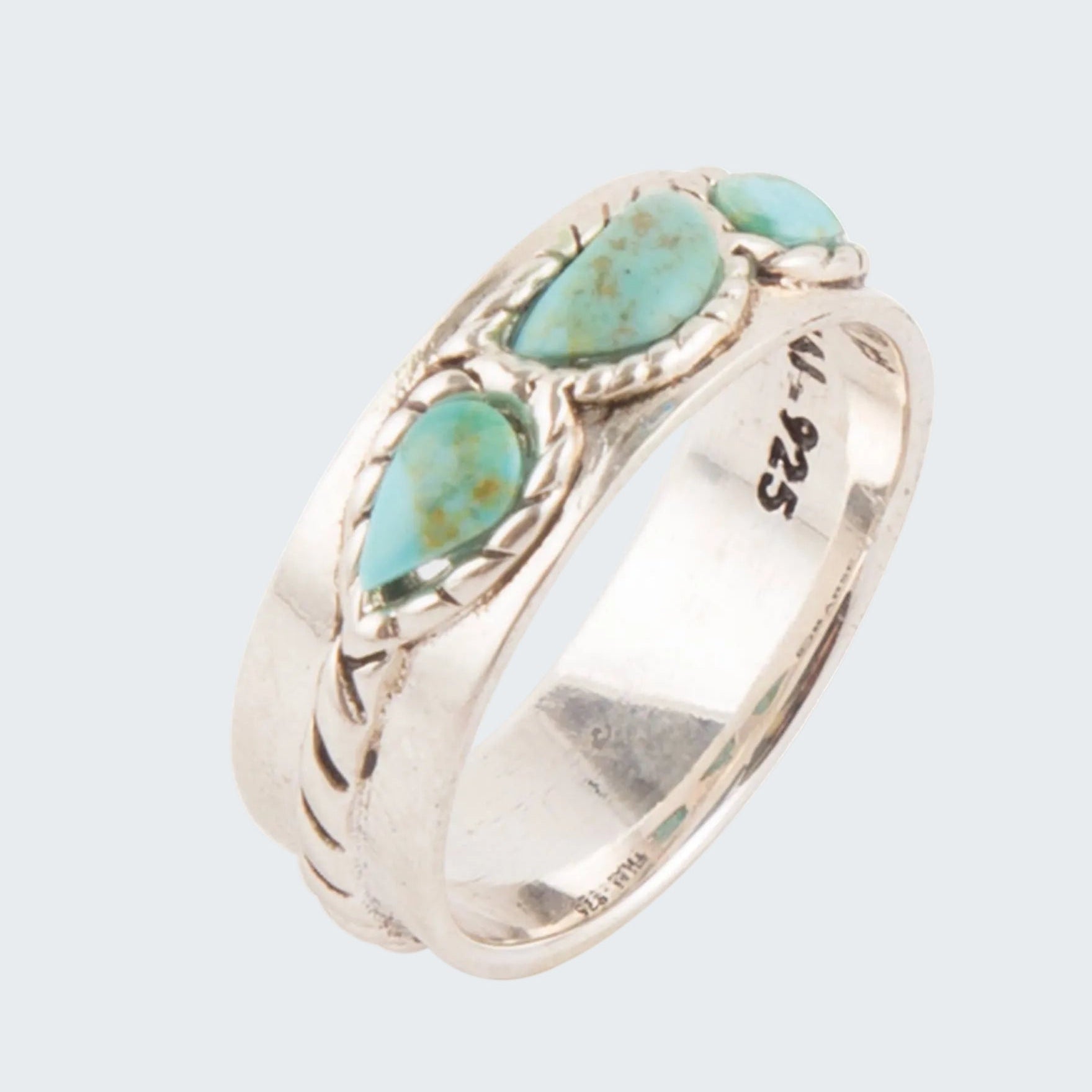 Silver ring with turquoise stones on a white background