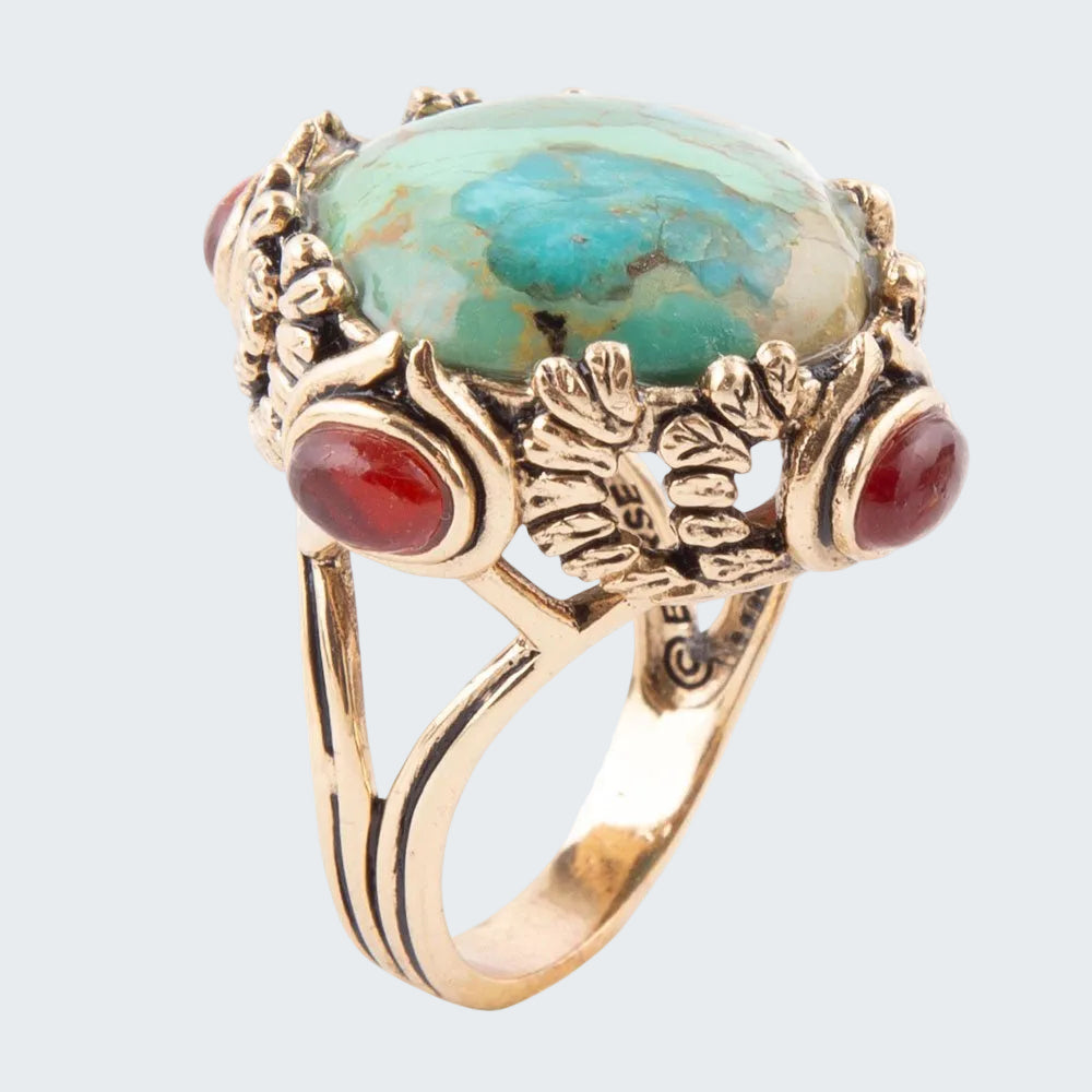 Gold ring with turquoise and red stone on a white background