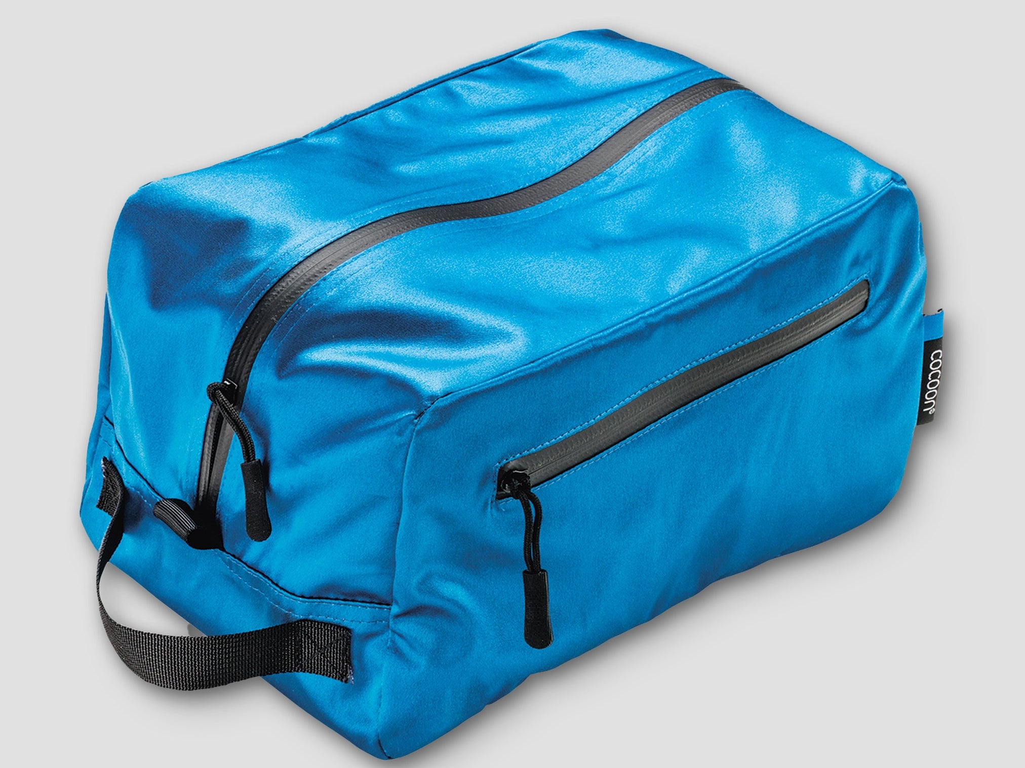 Blue toiletry bag with black zippers on a light gray background
