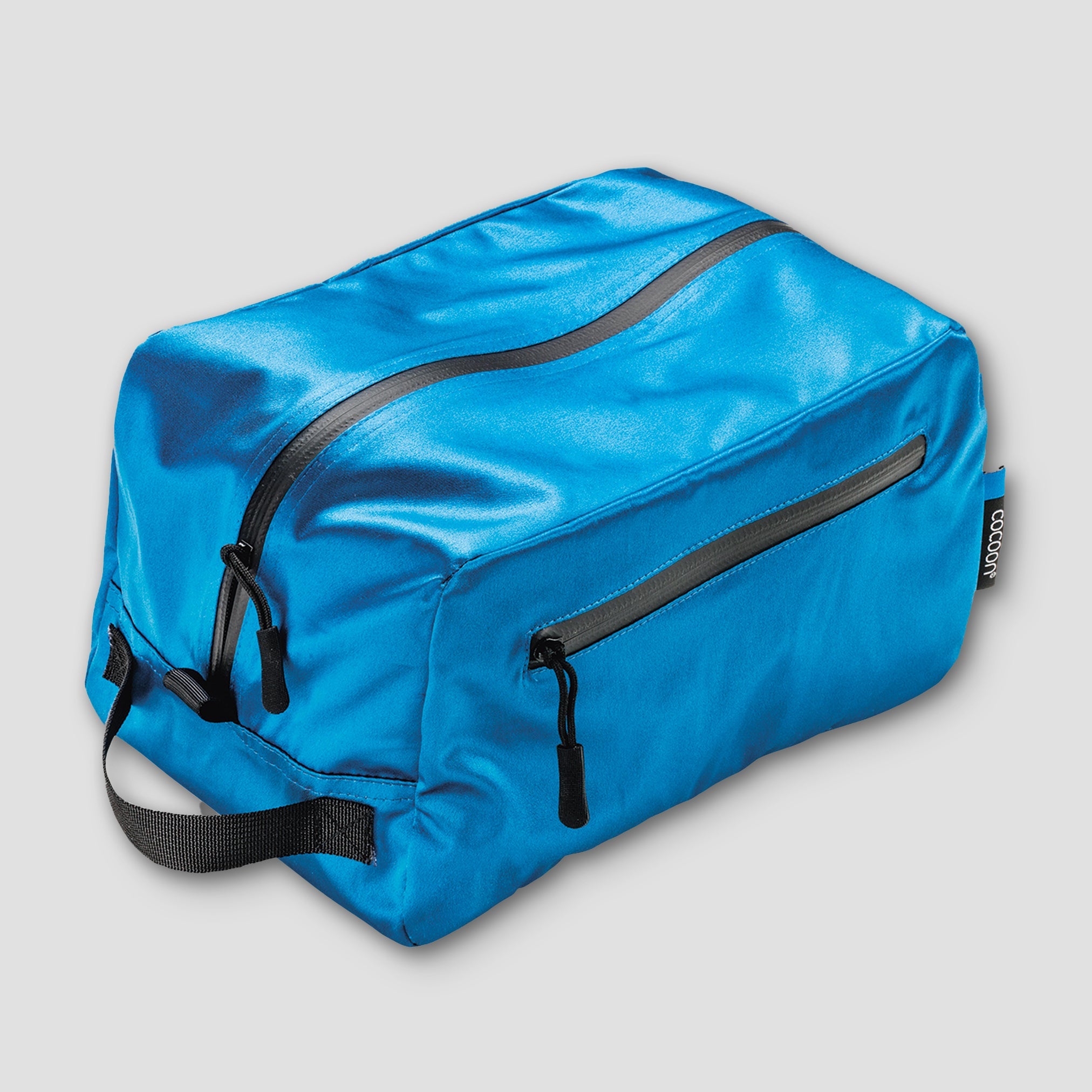 Blue toiletry bag with black zippers on a light gray background