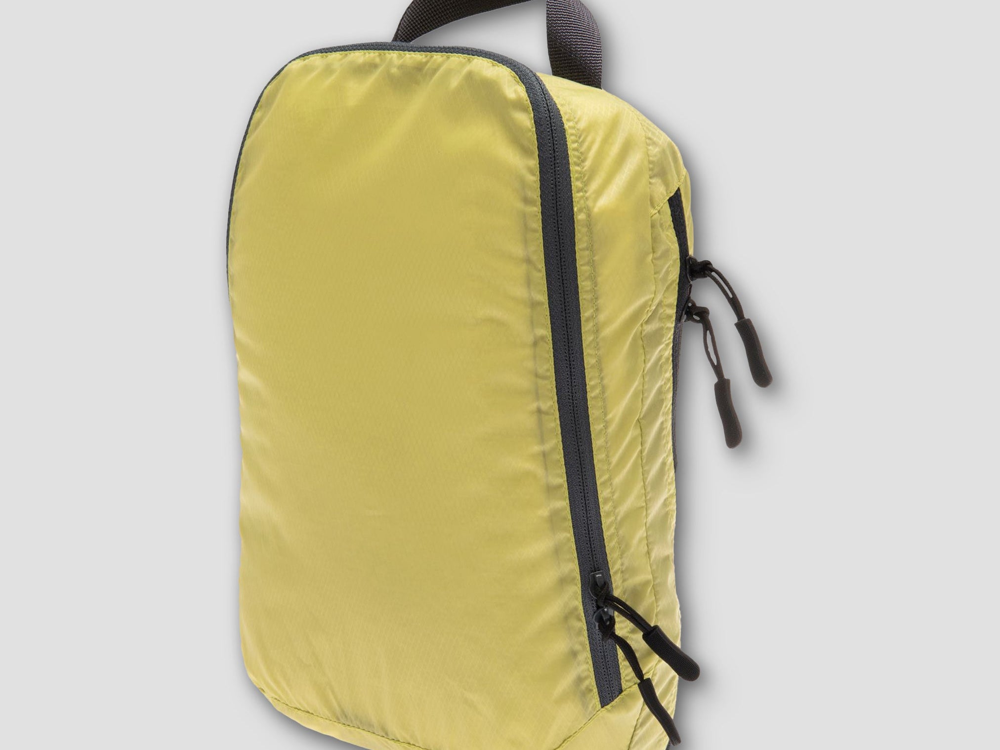 Yellow backpack with black zippers on a light gray background