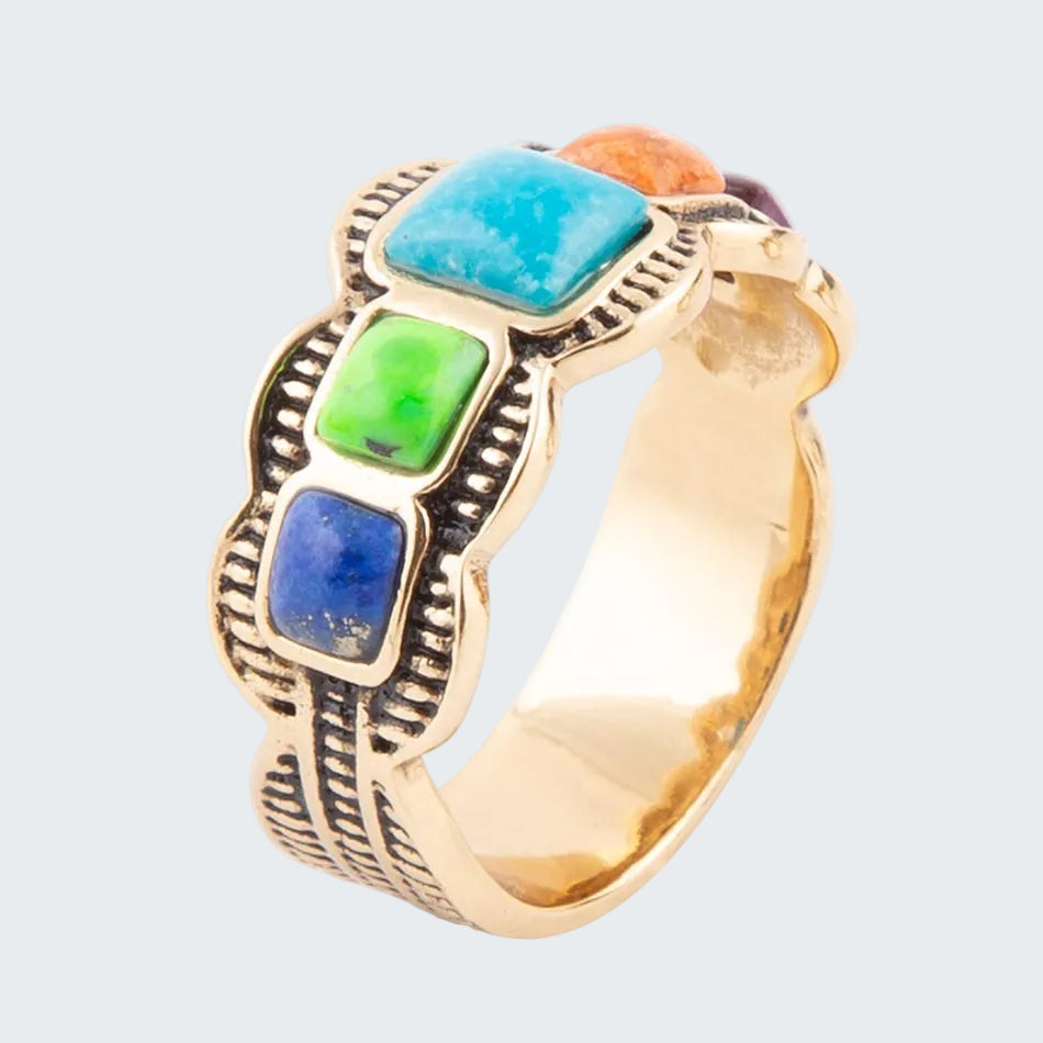 Gold ring with colorful gemstones on a white background