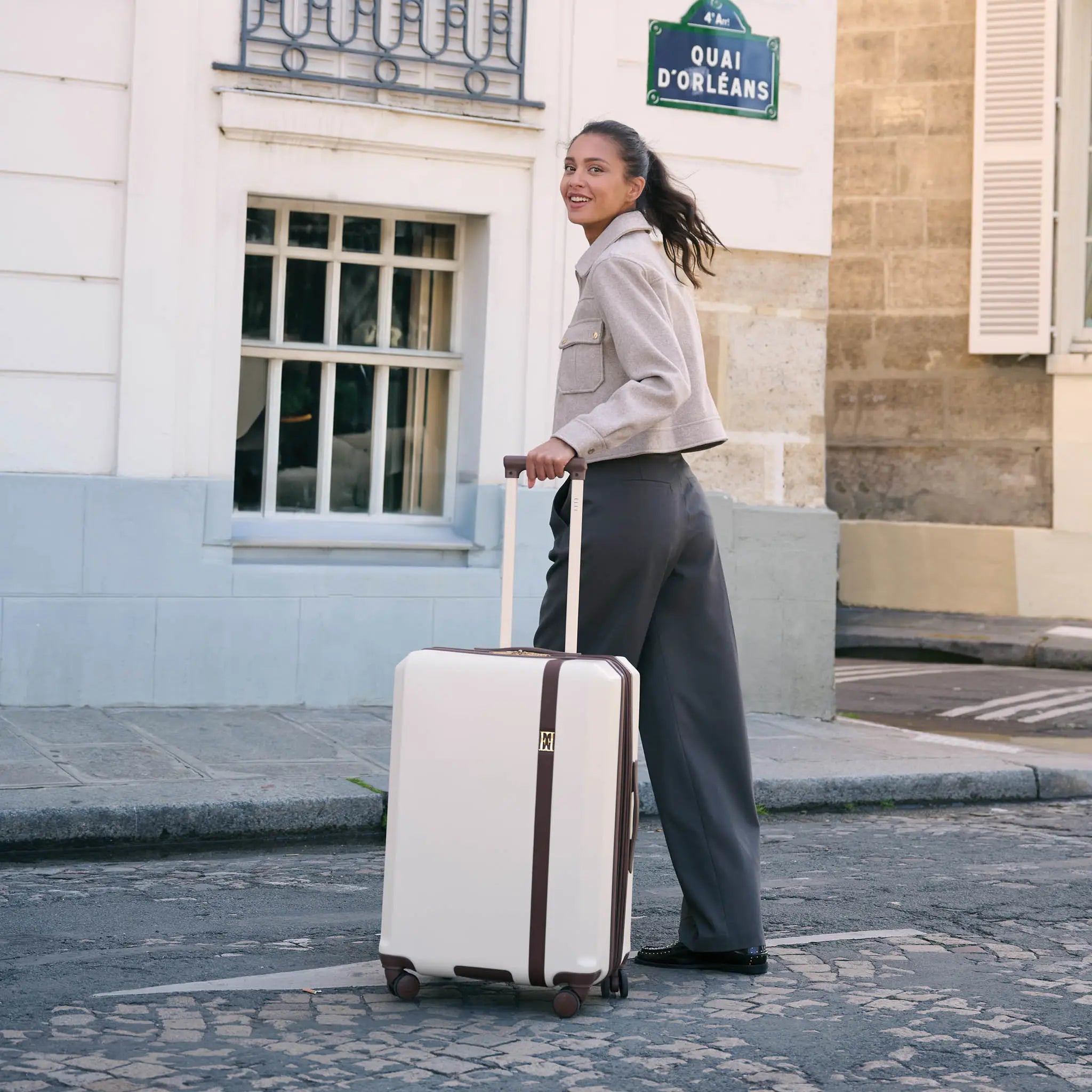 woman on a street rolling luggage