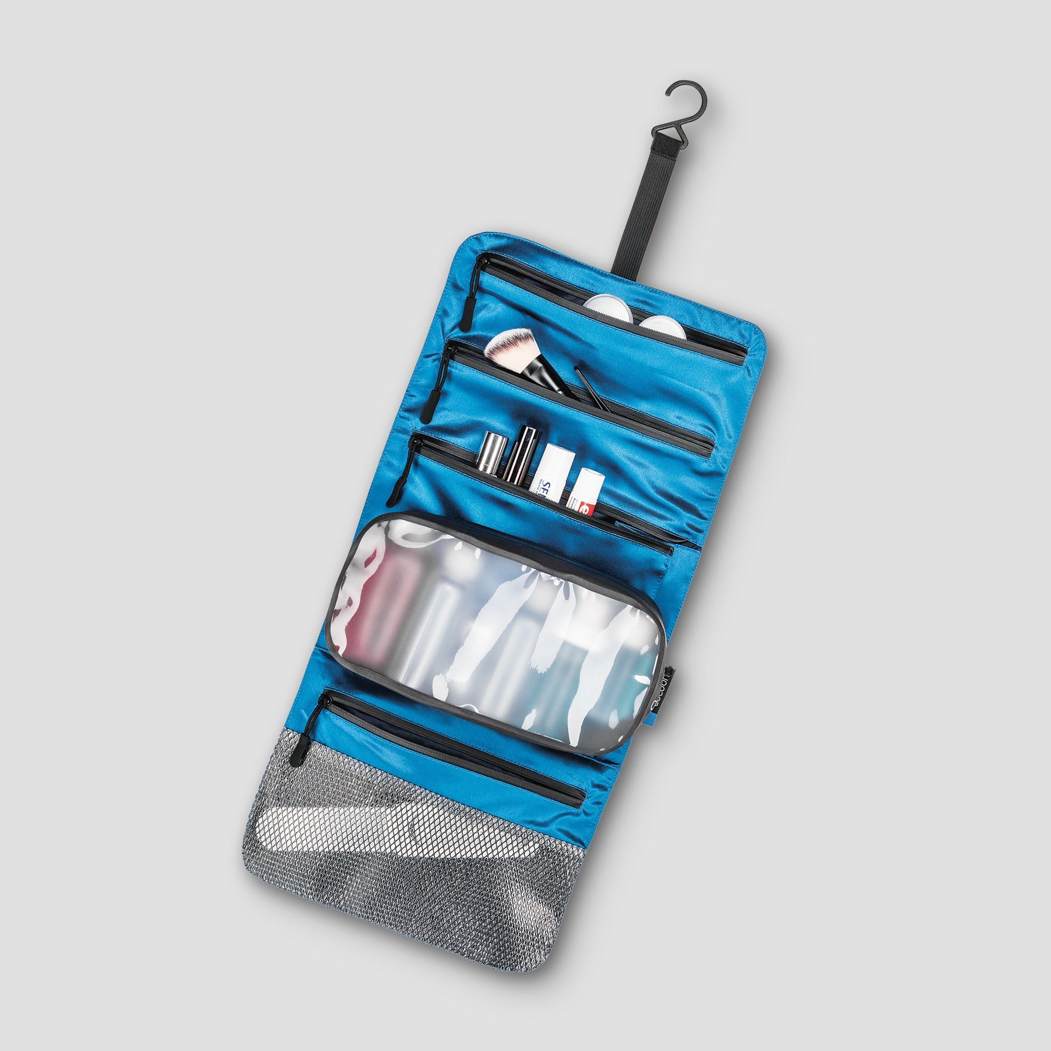 Blue and gray travel toiletry bag with items inside on a light gray background