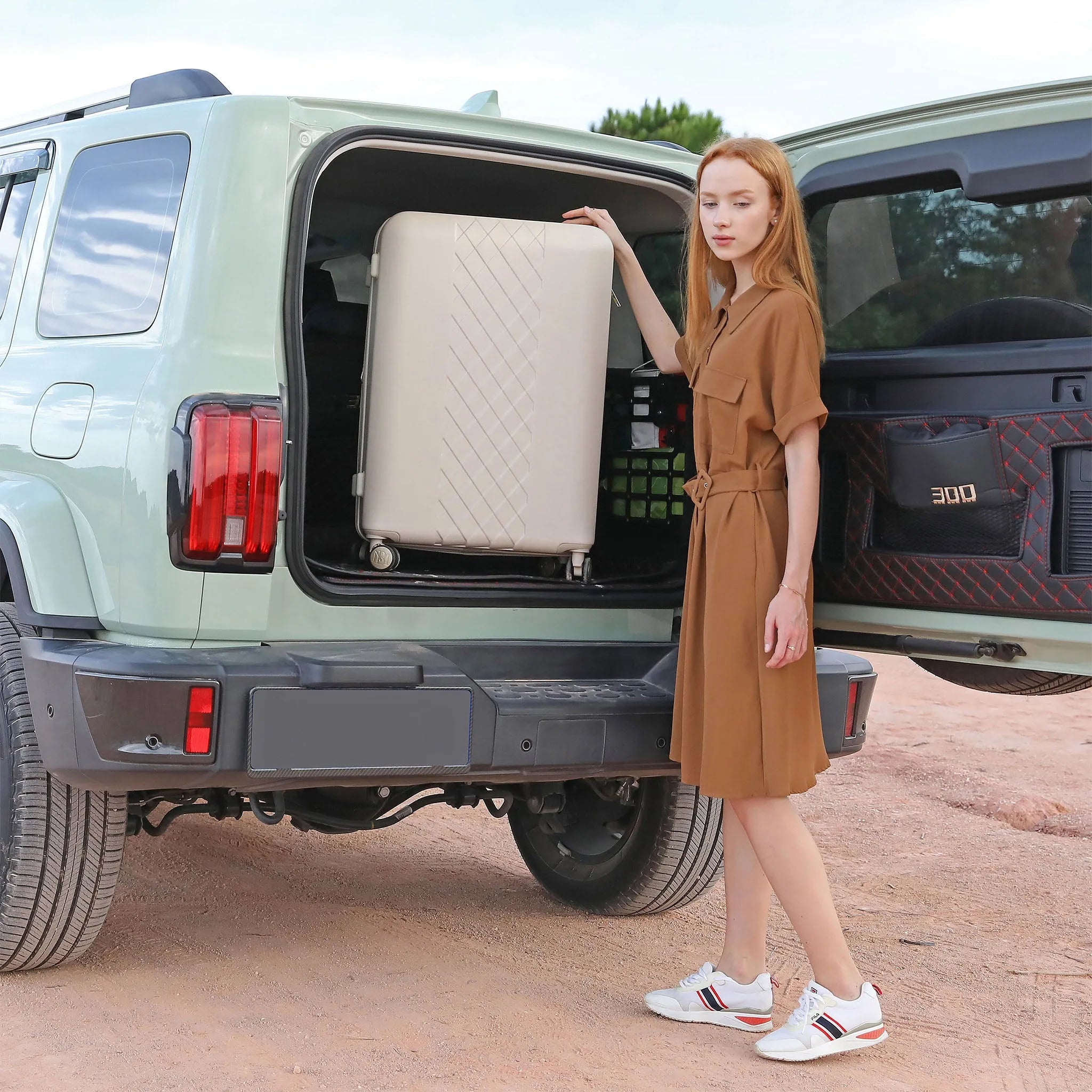 Woman loading a suitcase into the trunk of a light green SUV.