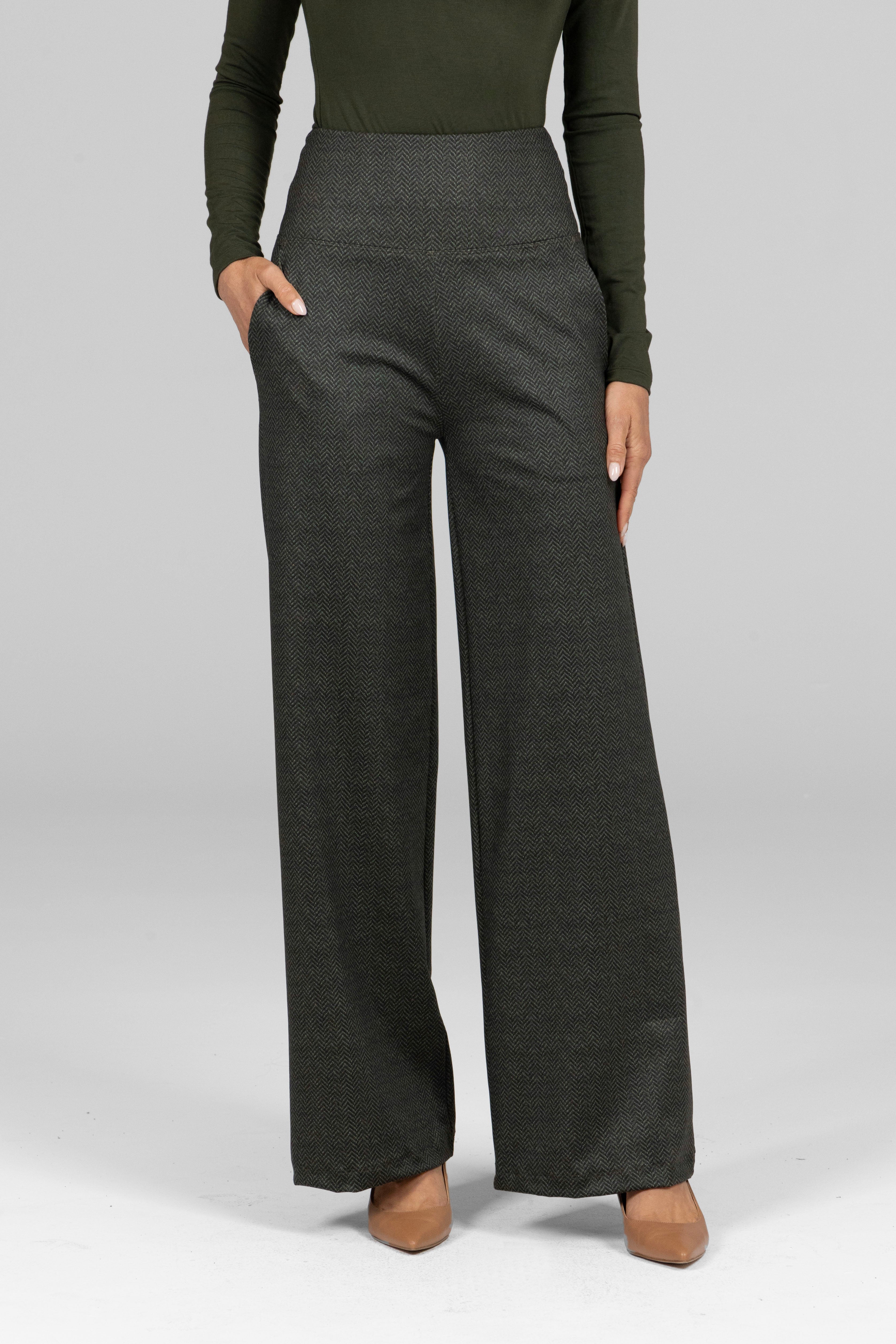 Person wearing dark gray wide-leg pants and a green long-sleeve top on a light gray background