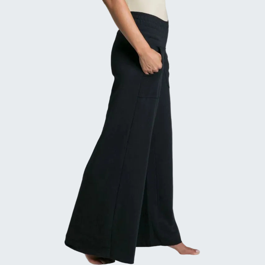 Person wearing black wide-leg pants on a plain background