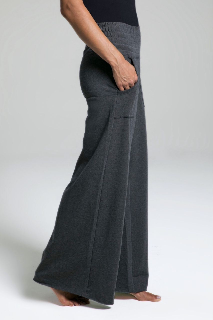 Person wearing dark gray wide-leg pants on a white background