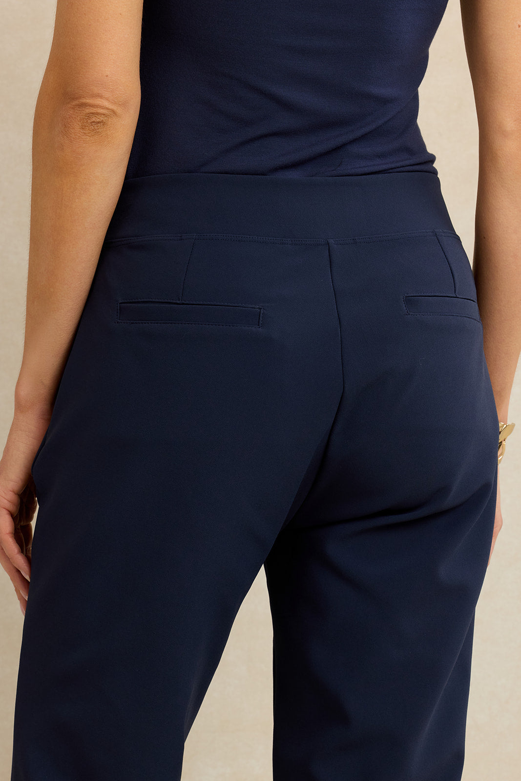 Navy blue pants worn by a person on a beige background